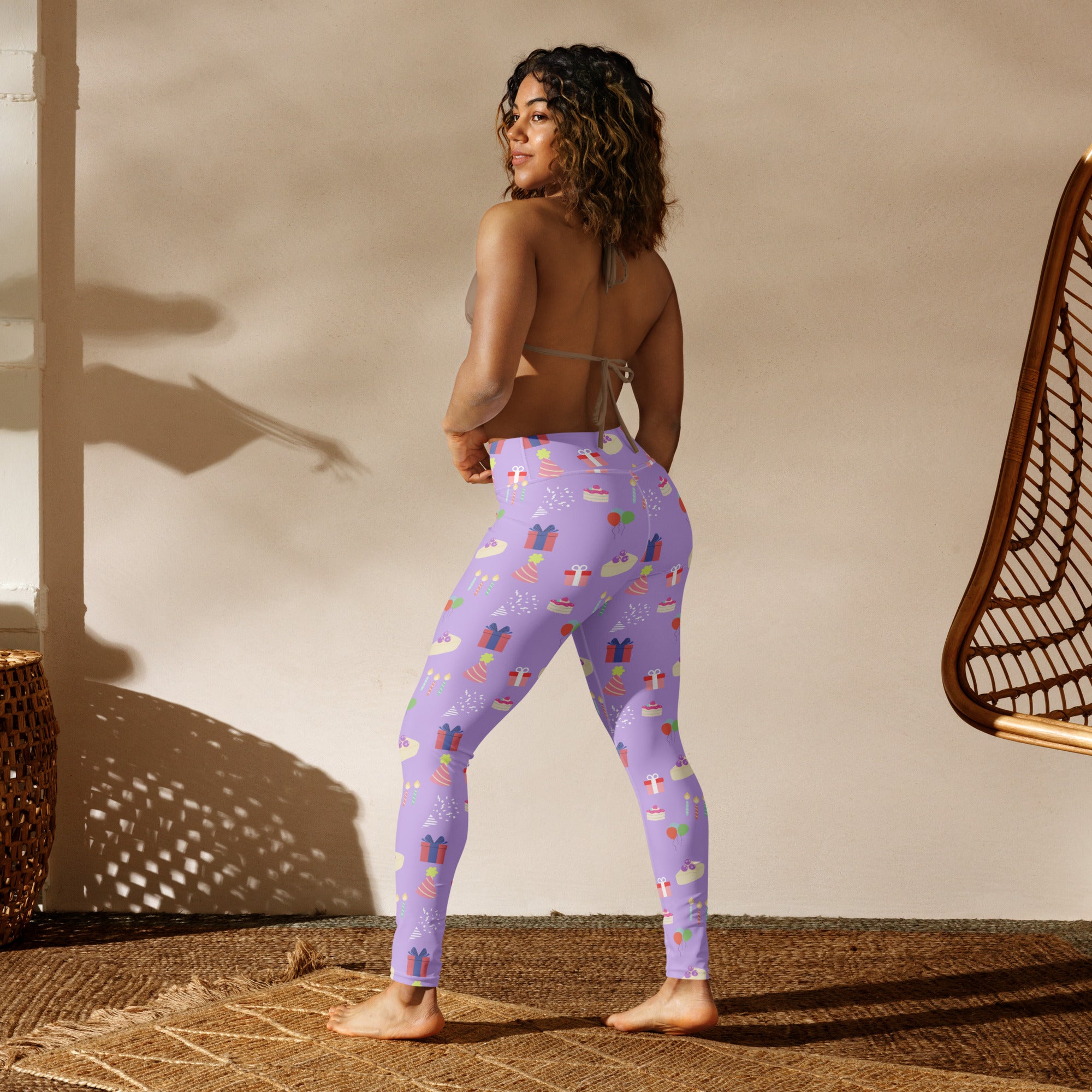Women’s purple buttery soft yoga leggings with festive birthday pattern of wrapped gifts cakes and holiday icons