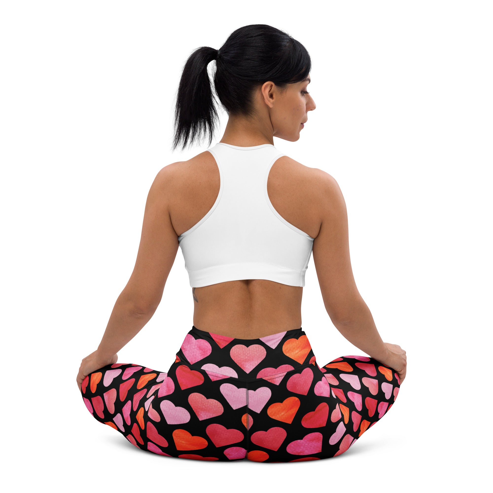Women’s high waisted black leggings with vibrant pink and orange watercolor hearts made of buttery soft quick drying fabric