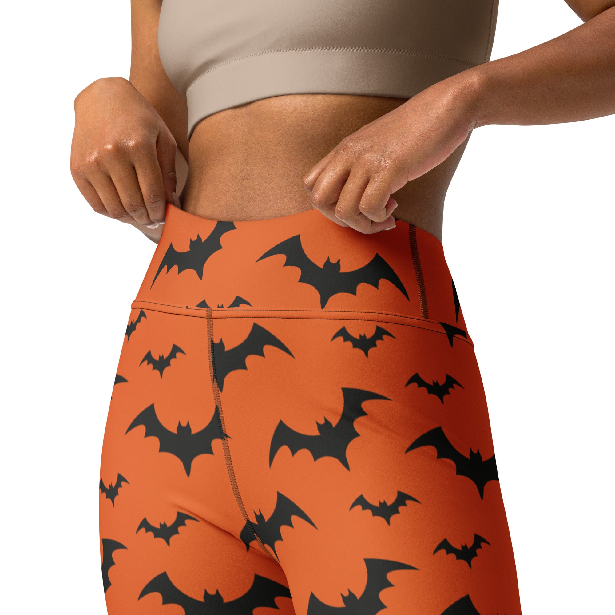 Women’s orange high-waisted yoga leggings with black bat prints perfect for halloween workouts