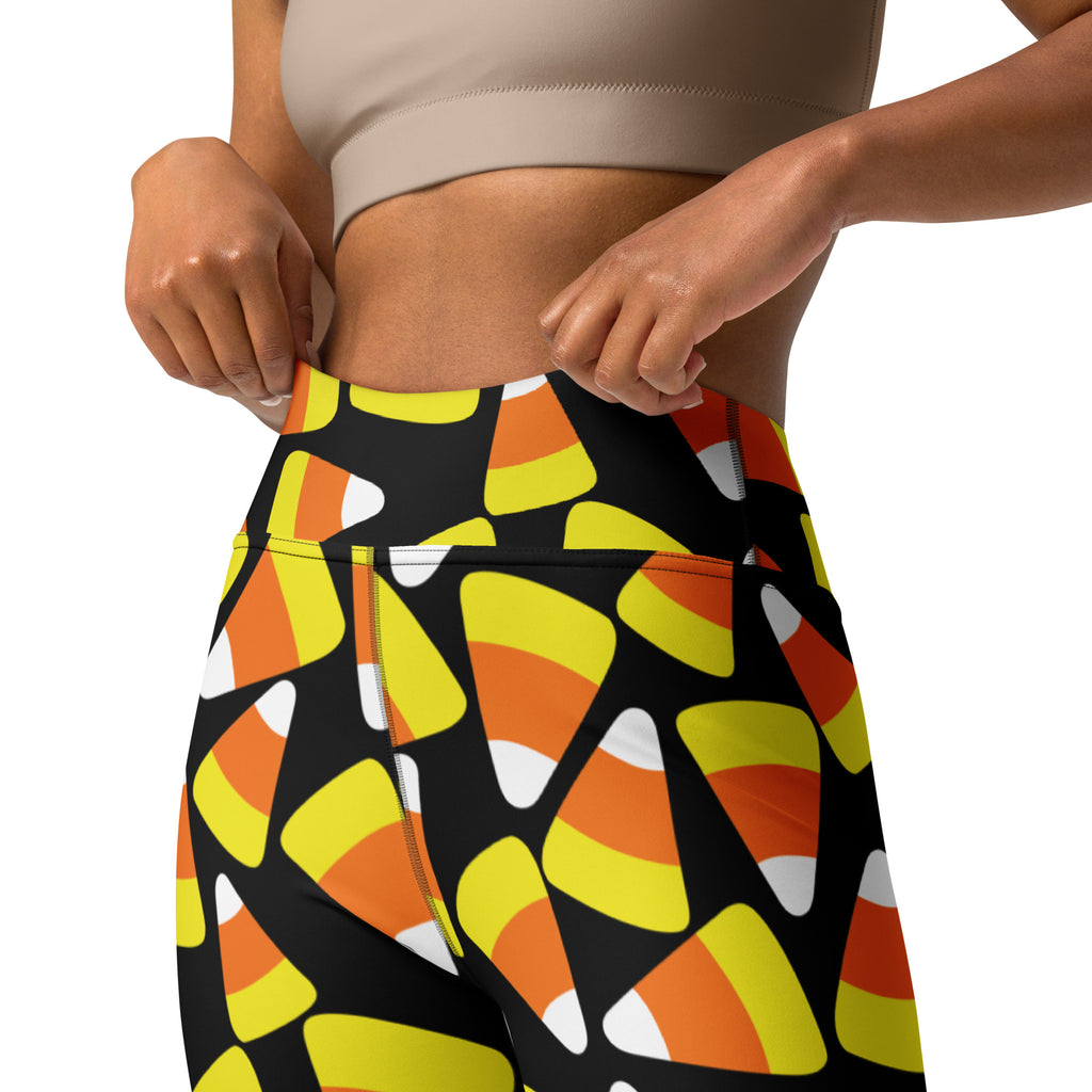 Women’s black high-waisted buttery soft yoga leggings with vibrant orange yellow and white candy corn pattern