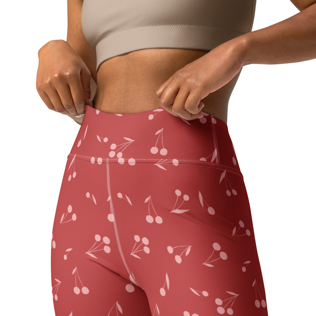 Women’s red cherry print high-waisted yoga leggings with buttery soft stretchy fabric for comfortable wear