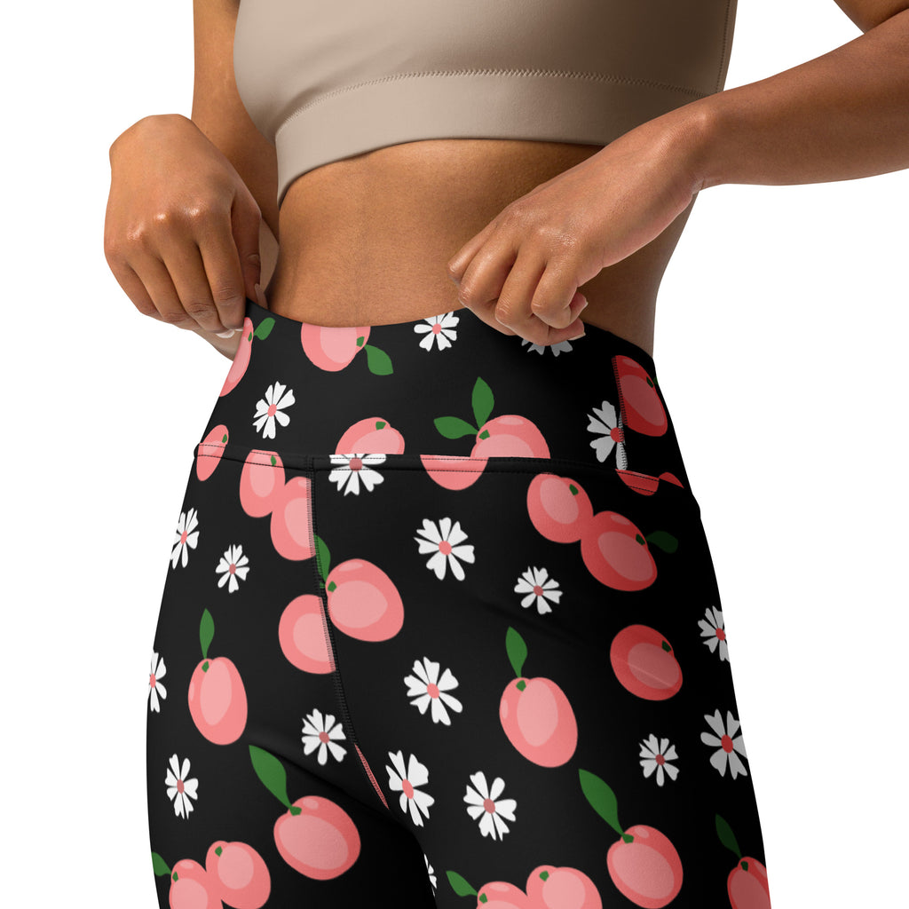Women’s black high-waisted buttery soft yoga leggings with playful pink peach and white daisy floral pattern