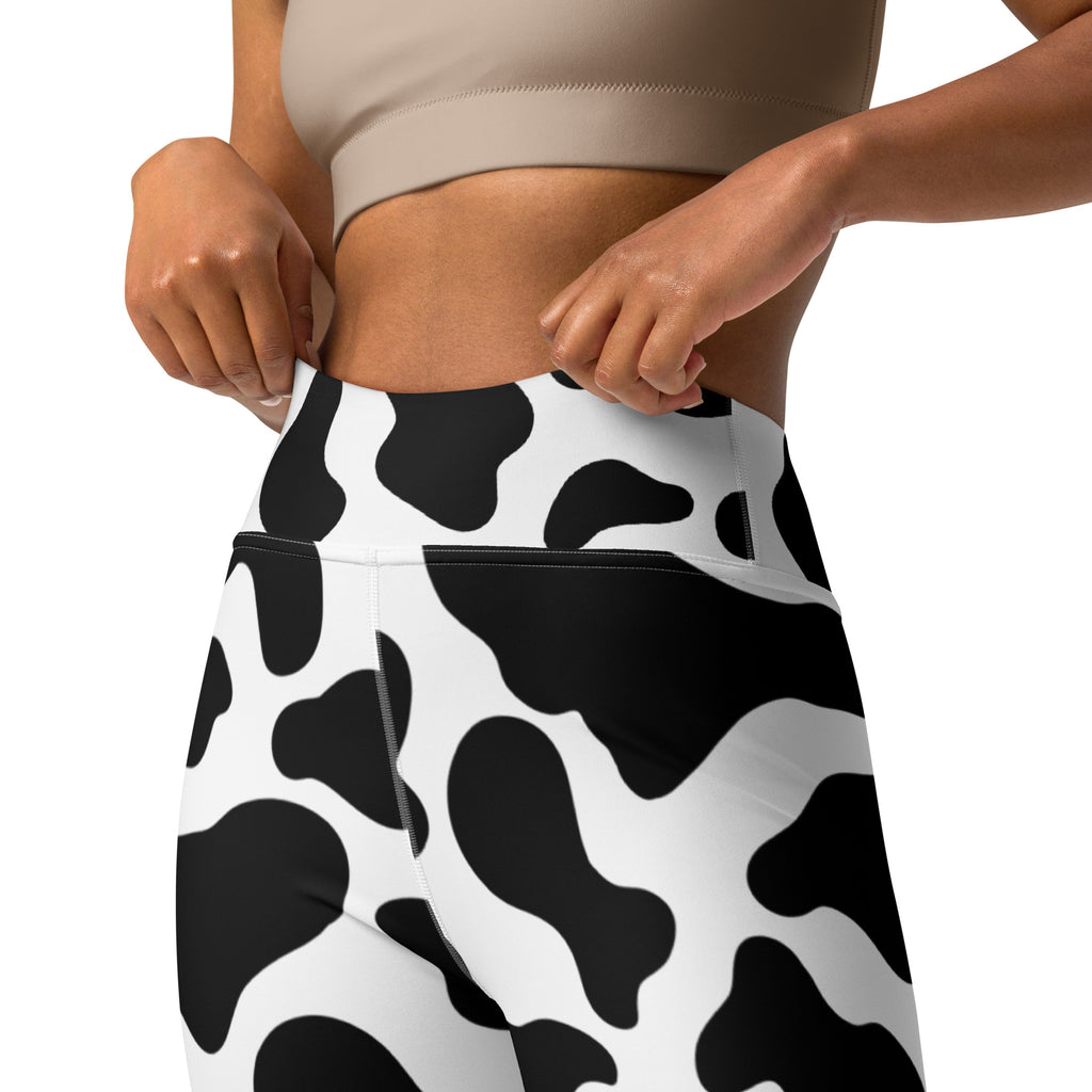 Women’s high-waisted cow print buttery soft yoga leggings in black and white showing the back view