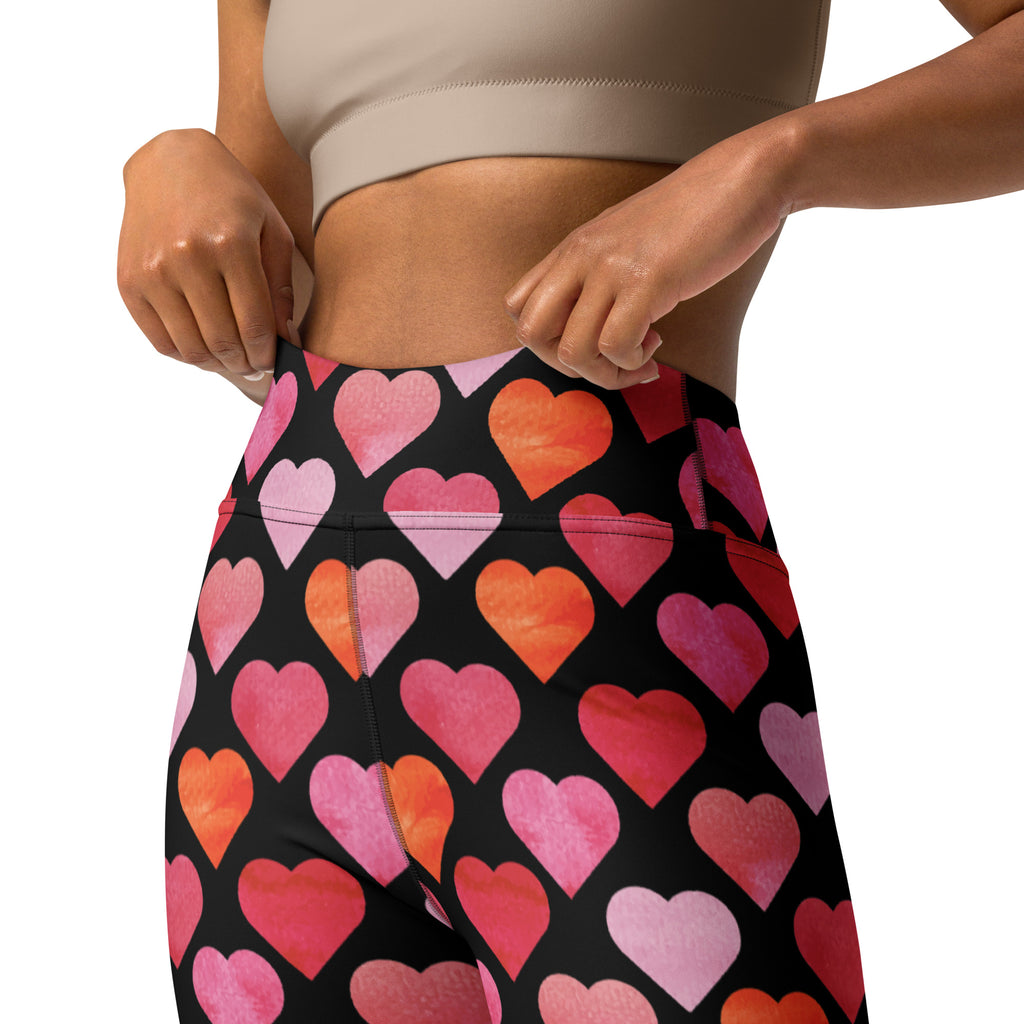Black high waisted buttery soft yoga leggings with vibrant pink orange and red watercolor heart pattern