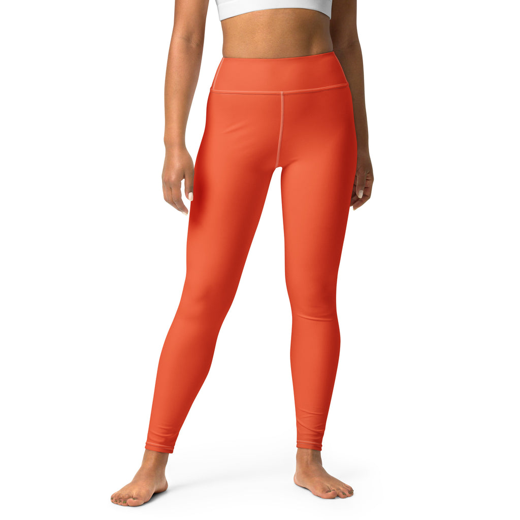 A pair of women’s orange buttery soft high-waisted yoga leggings made from stretchy, form-fitting fabric