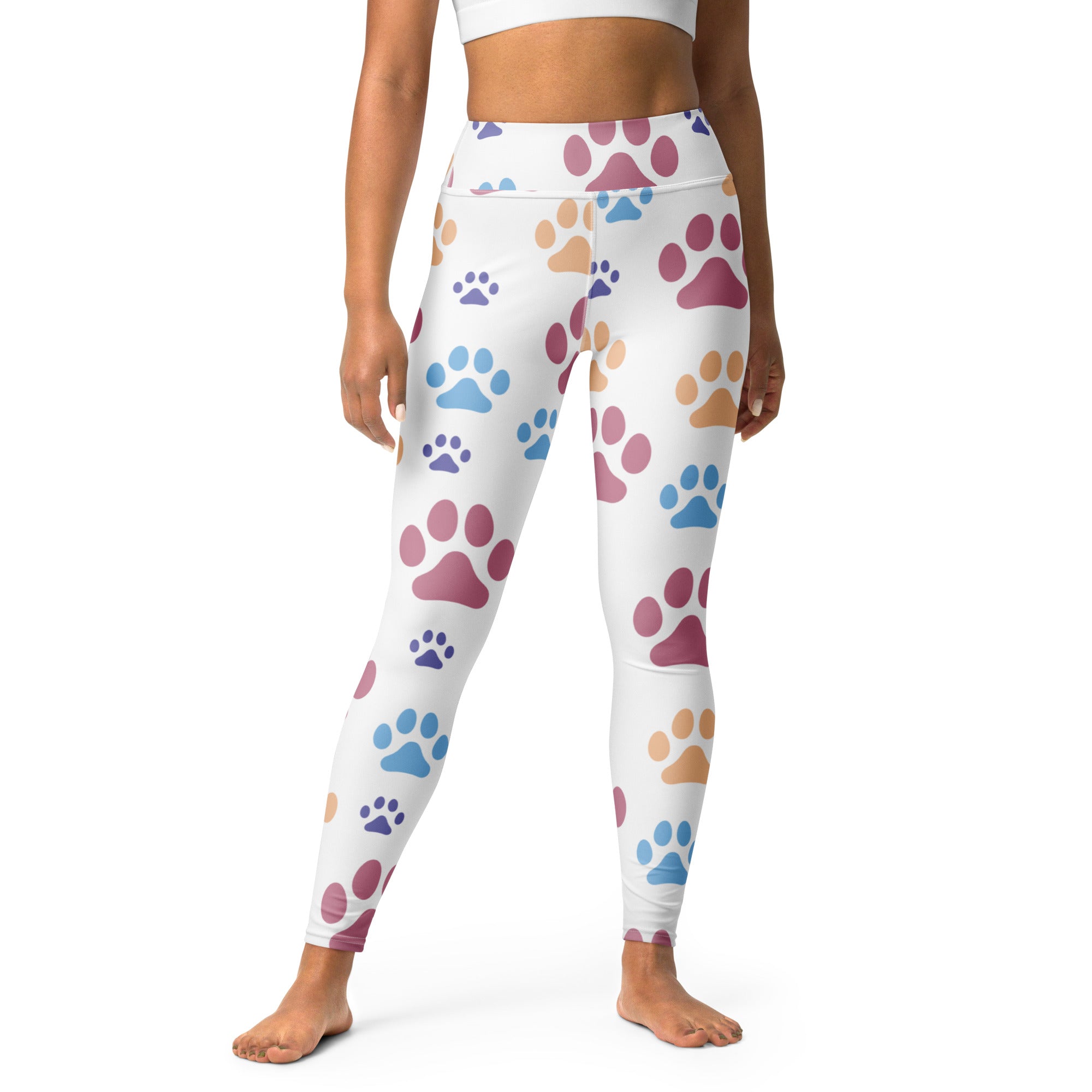 White buttery soft women’s yoga leggings with colorful pink blue and tan paw print pattern