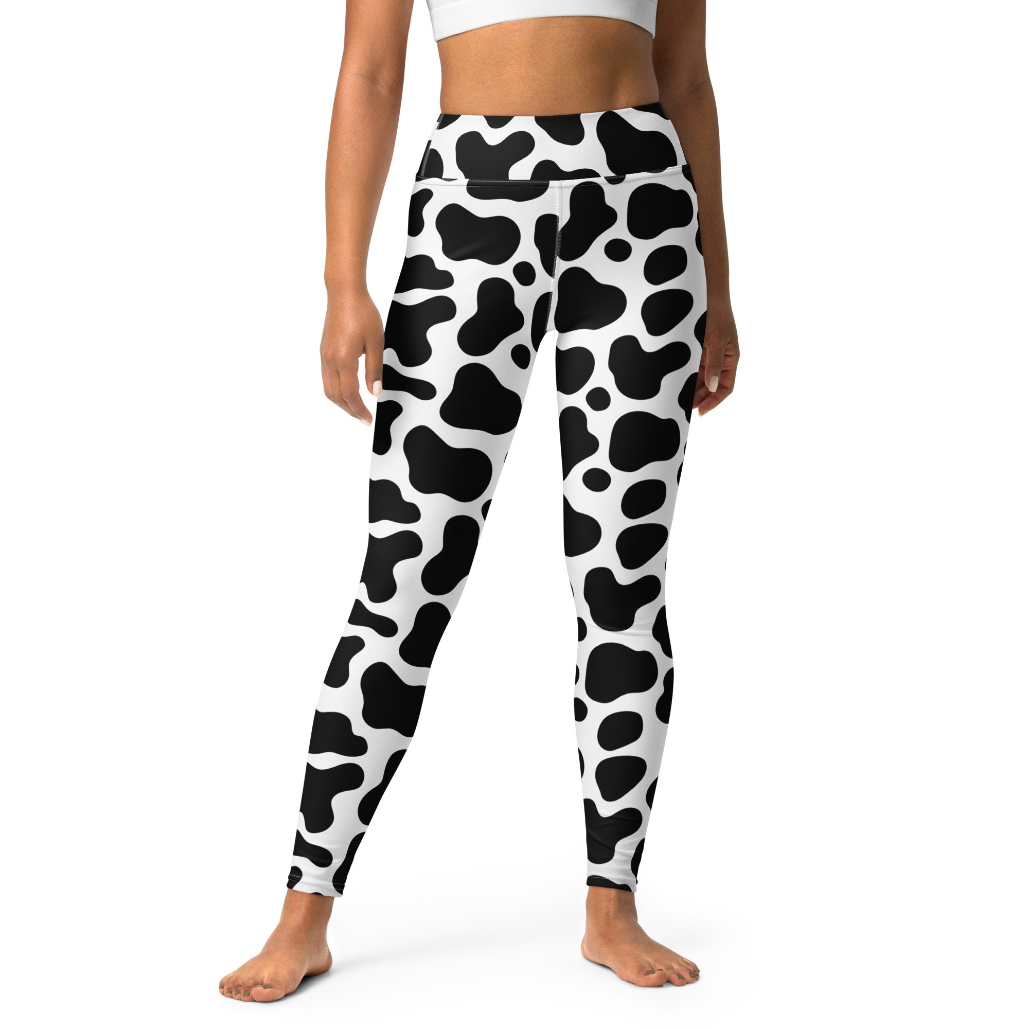 Women’s buttery soft high-waisted yoga leggings in black and white cow print shown from the back side
