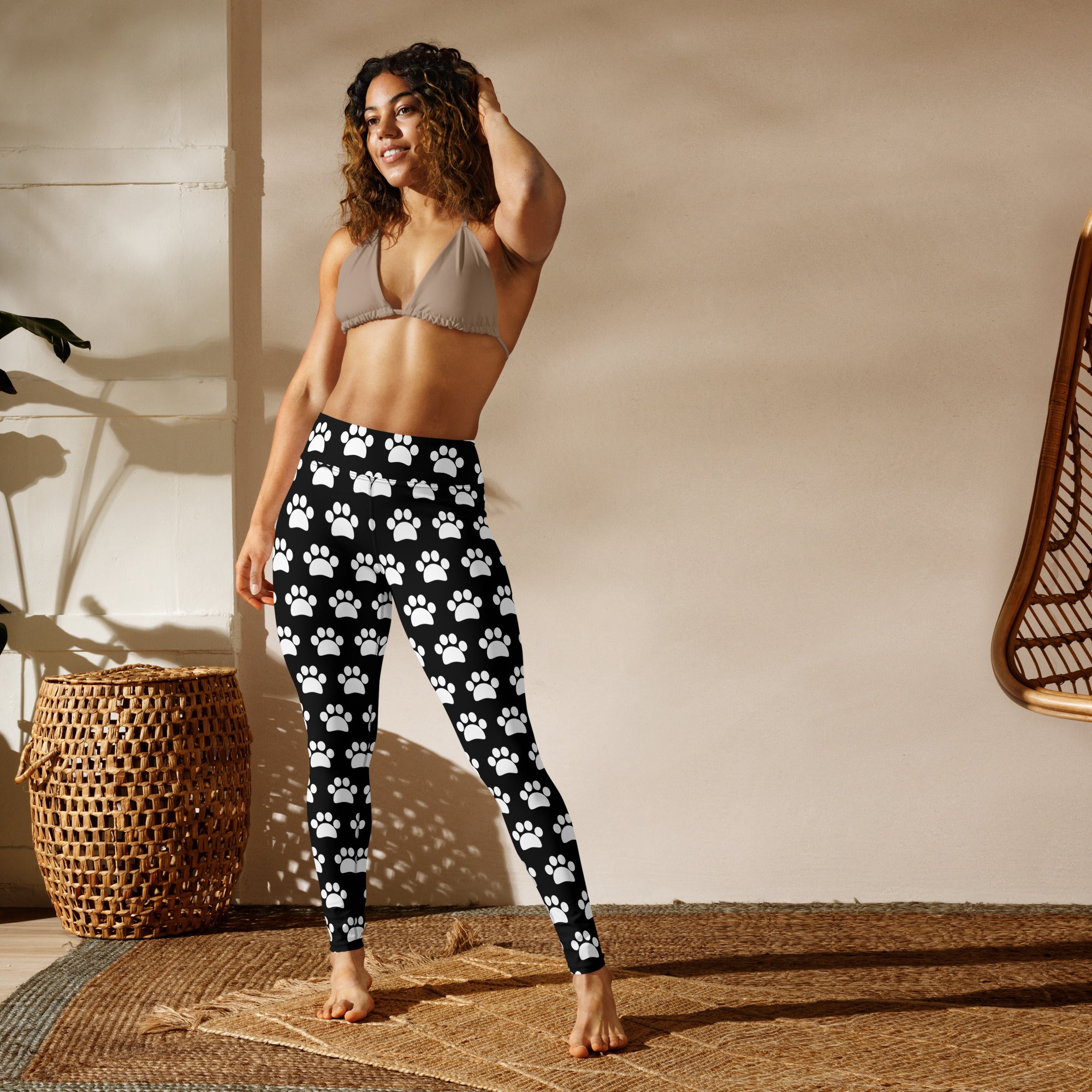 Women’s black and white paw print buttery soft yoga leggings featuring a repeating pattern of white paw prints