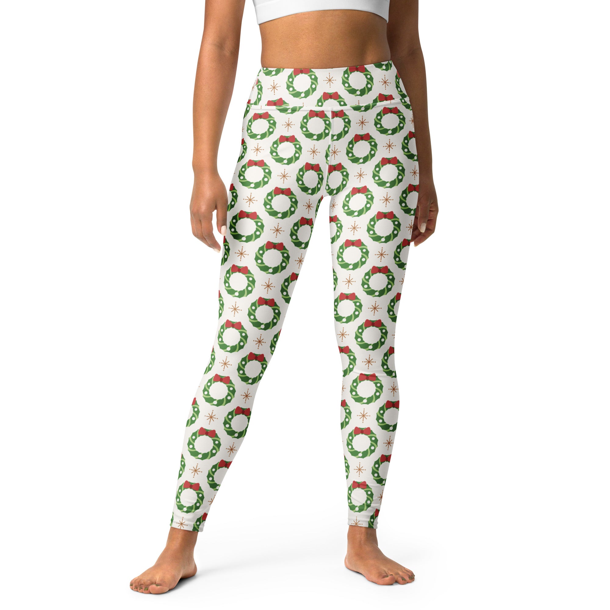 White buttery soft women’s yoga leggings with green christmas wreaths red bows and starburst accents pattern