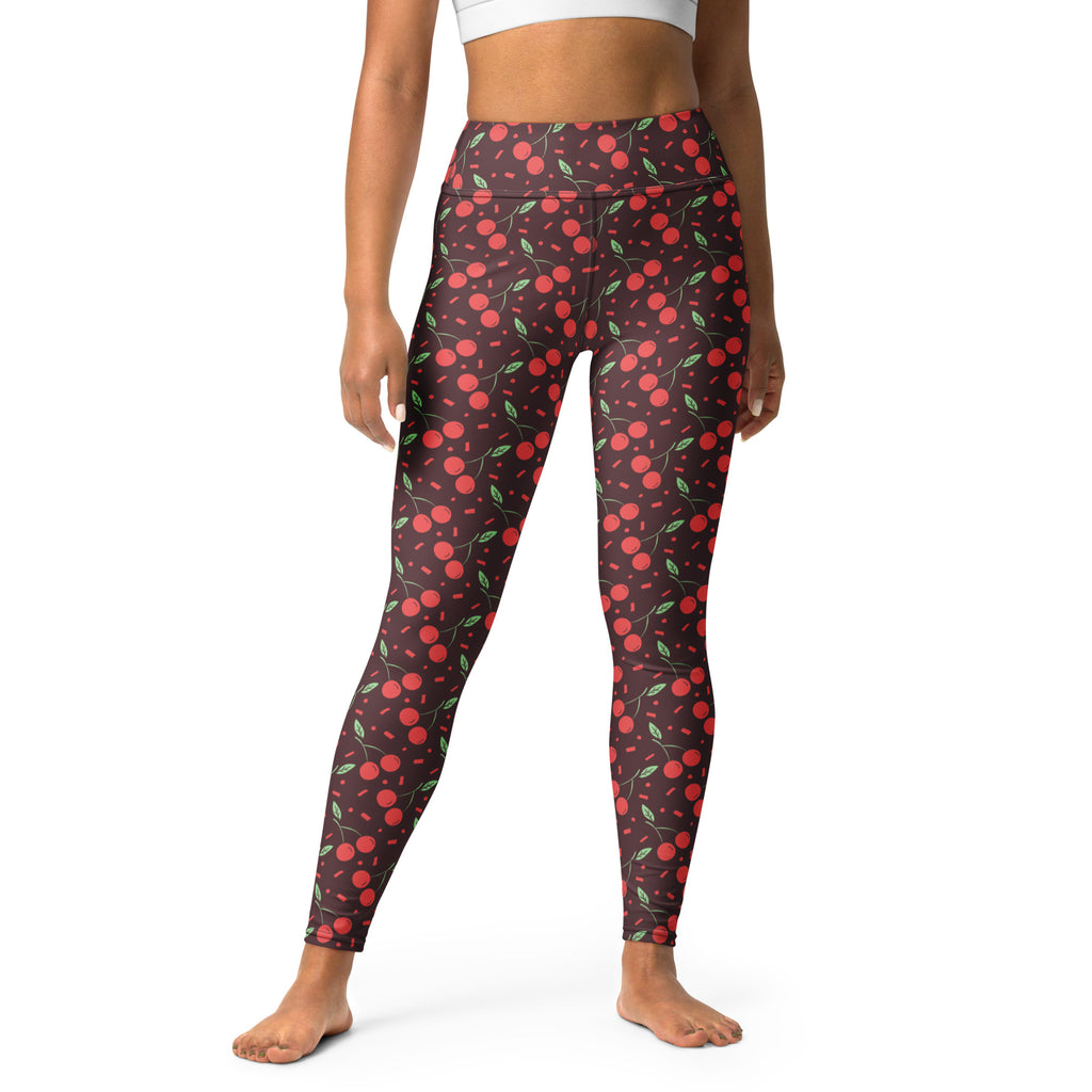 Women’s red cherry buttery soft yoga leggings with high waist and green leaf pattern on dark background