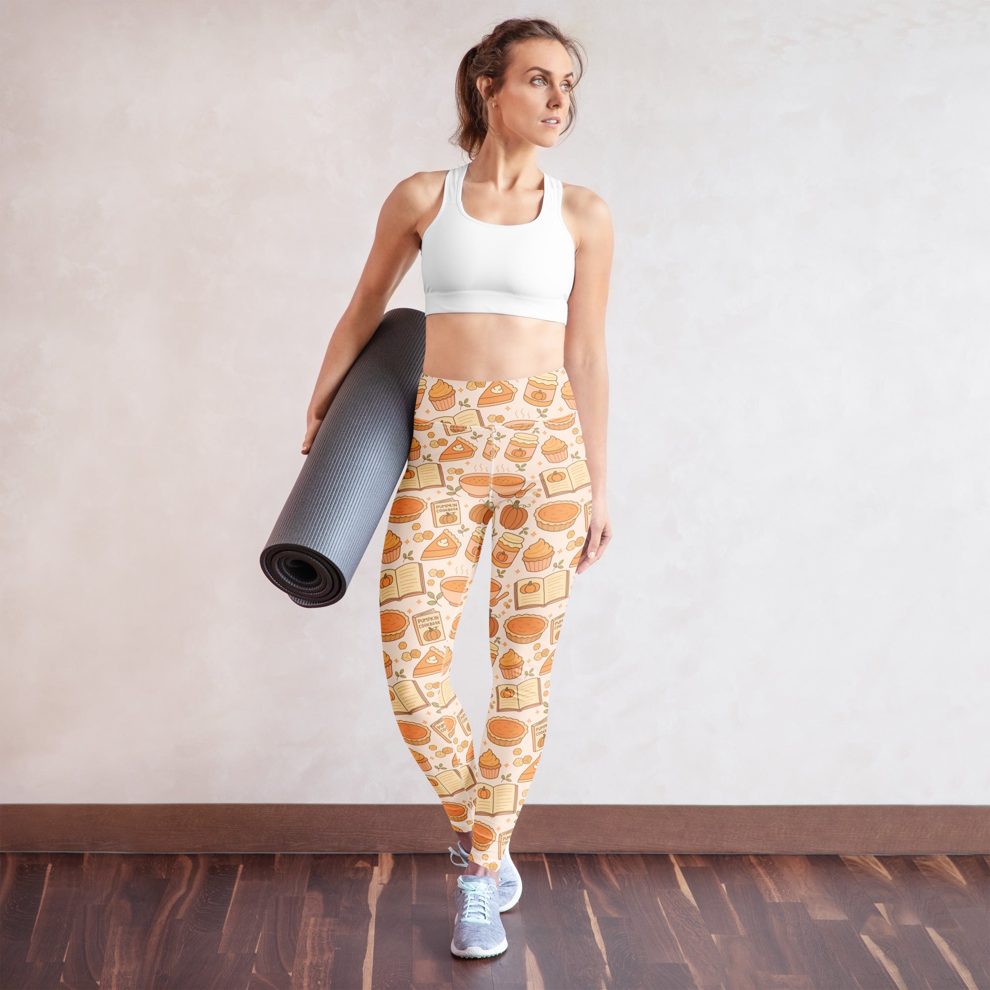 Women’s buttery soft beige yoga leggings with a playful pumpkin pie themed pattern of pies cupcakes and books