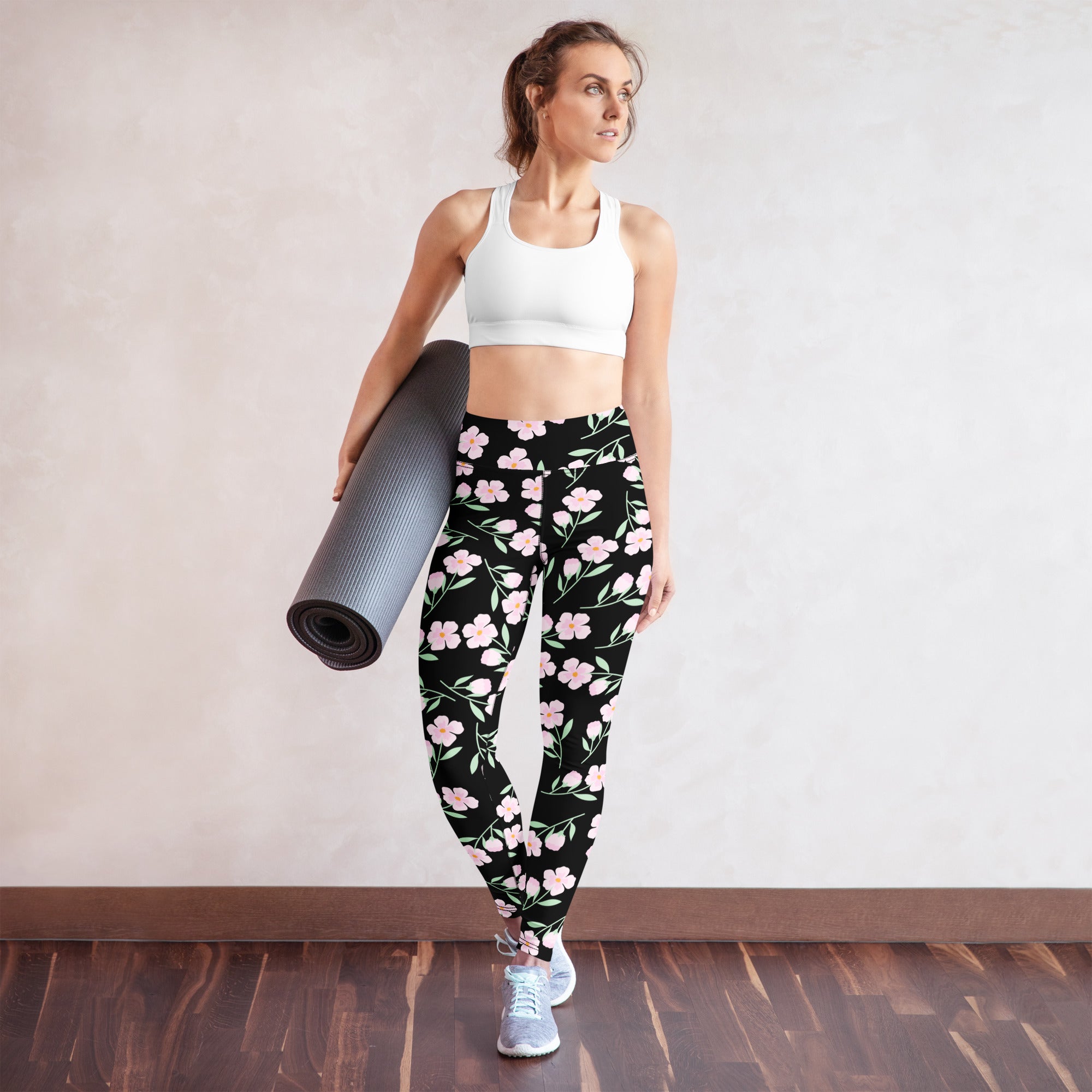 Women’s black buttery soft yoga leggings with delicate pink floral pattern on front side