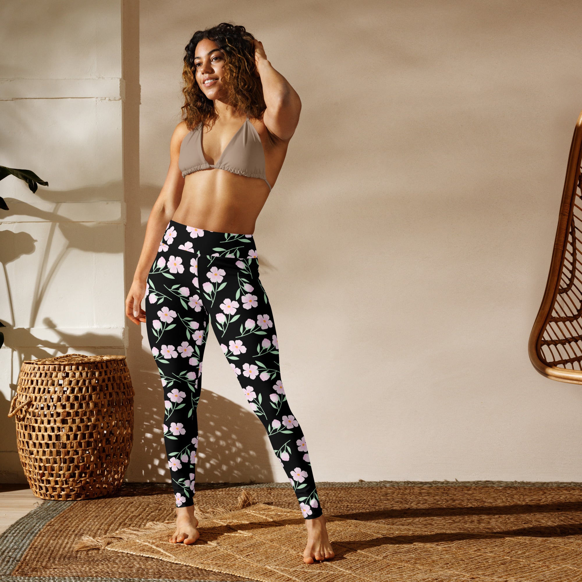 Women’s black buttery soft yoga leggings with delicate pink floral pattern on fabric front side