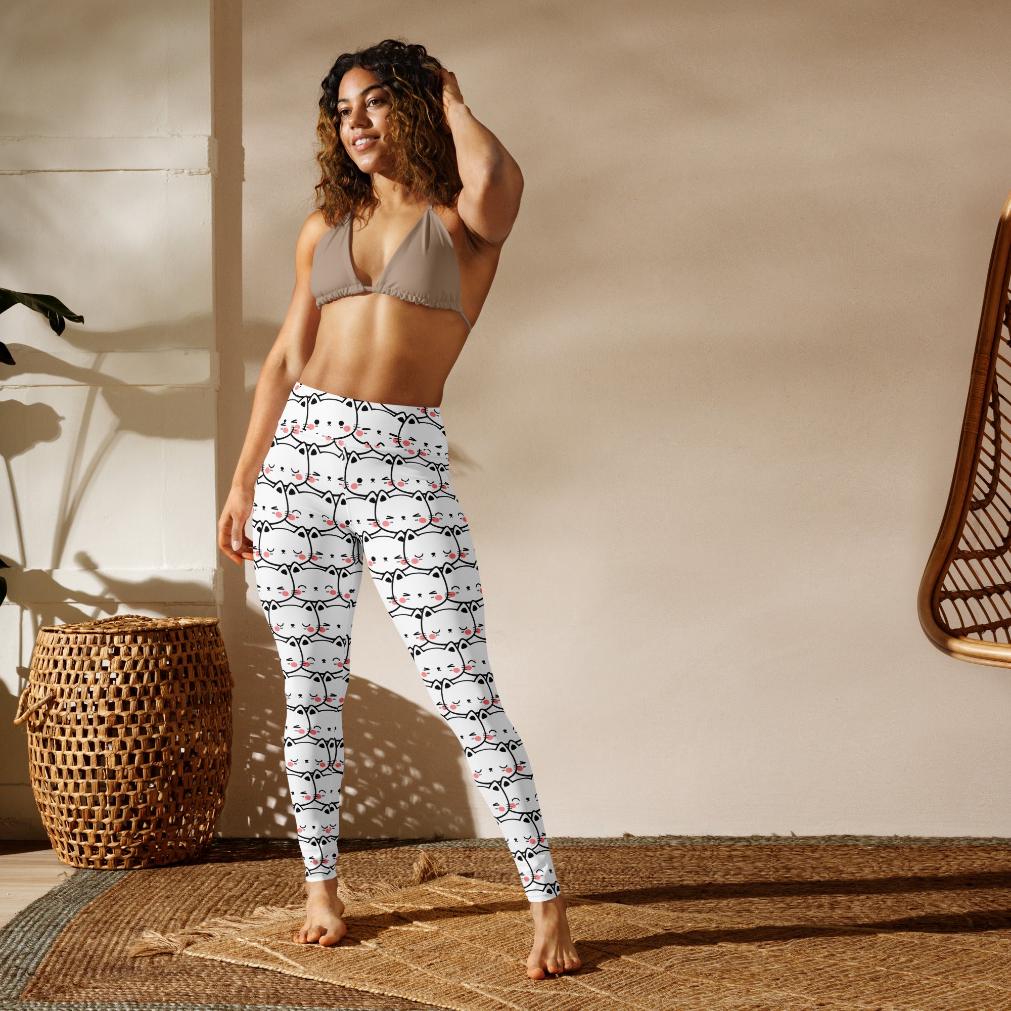 Women’s white buttery soft yoga leggings with a repeating pattern of stylized cartoon cats in black and pink accents