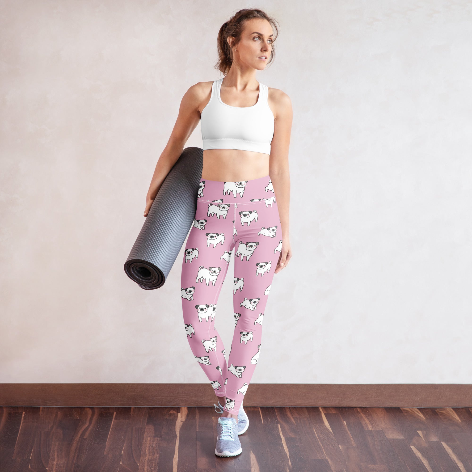 Women’s pink buttery soft yoga leggings with a repeating pattern of white pug illustrations