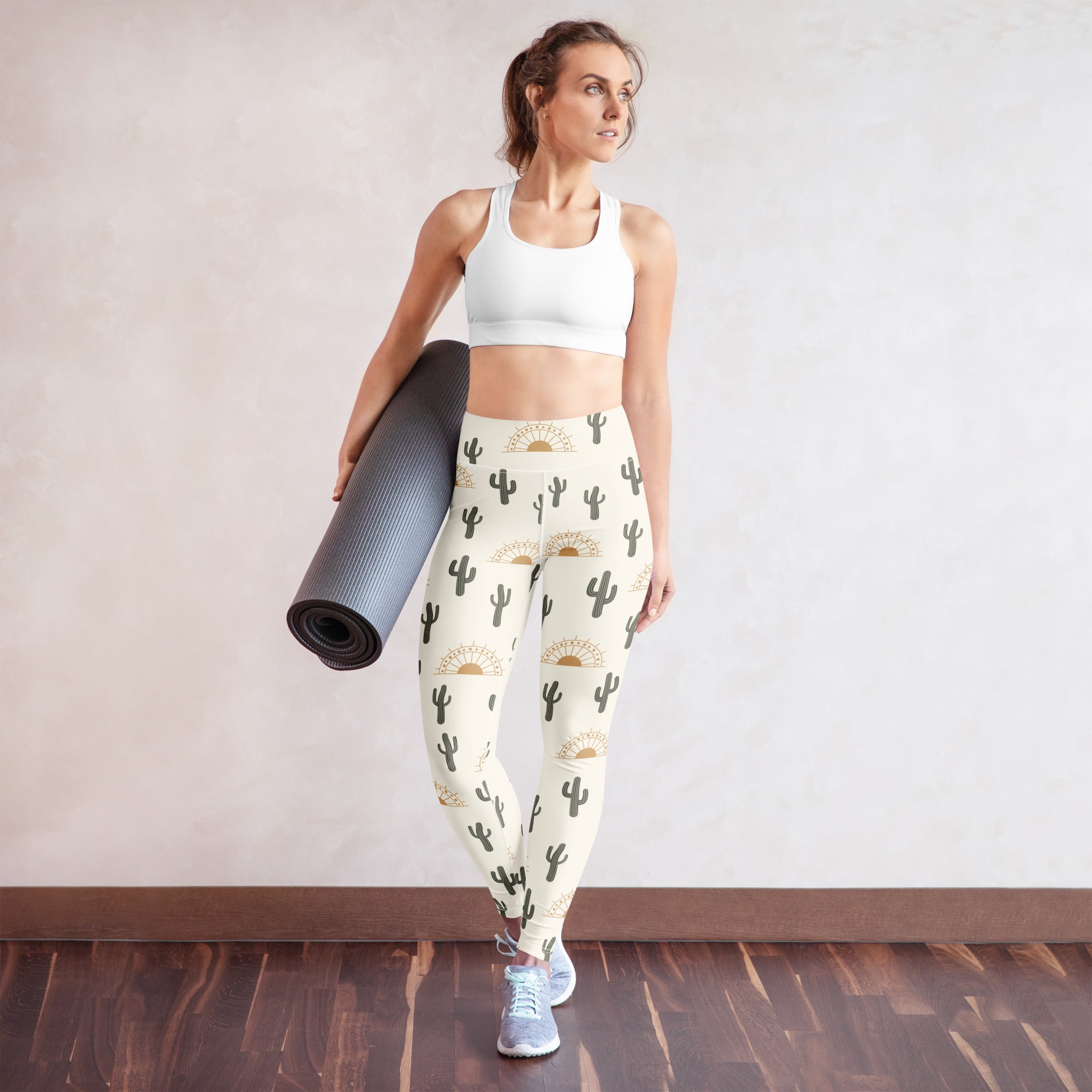 Cream-colored buttery soft women’s yoga leggings with black cactus and golden sun patterns from cactus desert sunrise