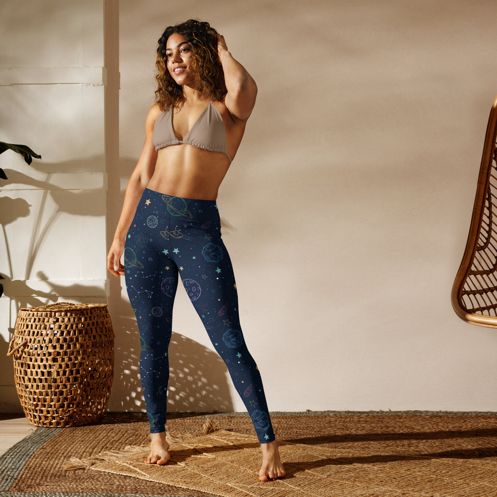Dark blue high-waisted buttery soft yoga leggings with a colorful celestial pattern of planets stars and moons
