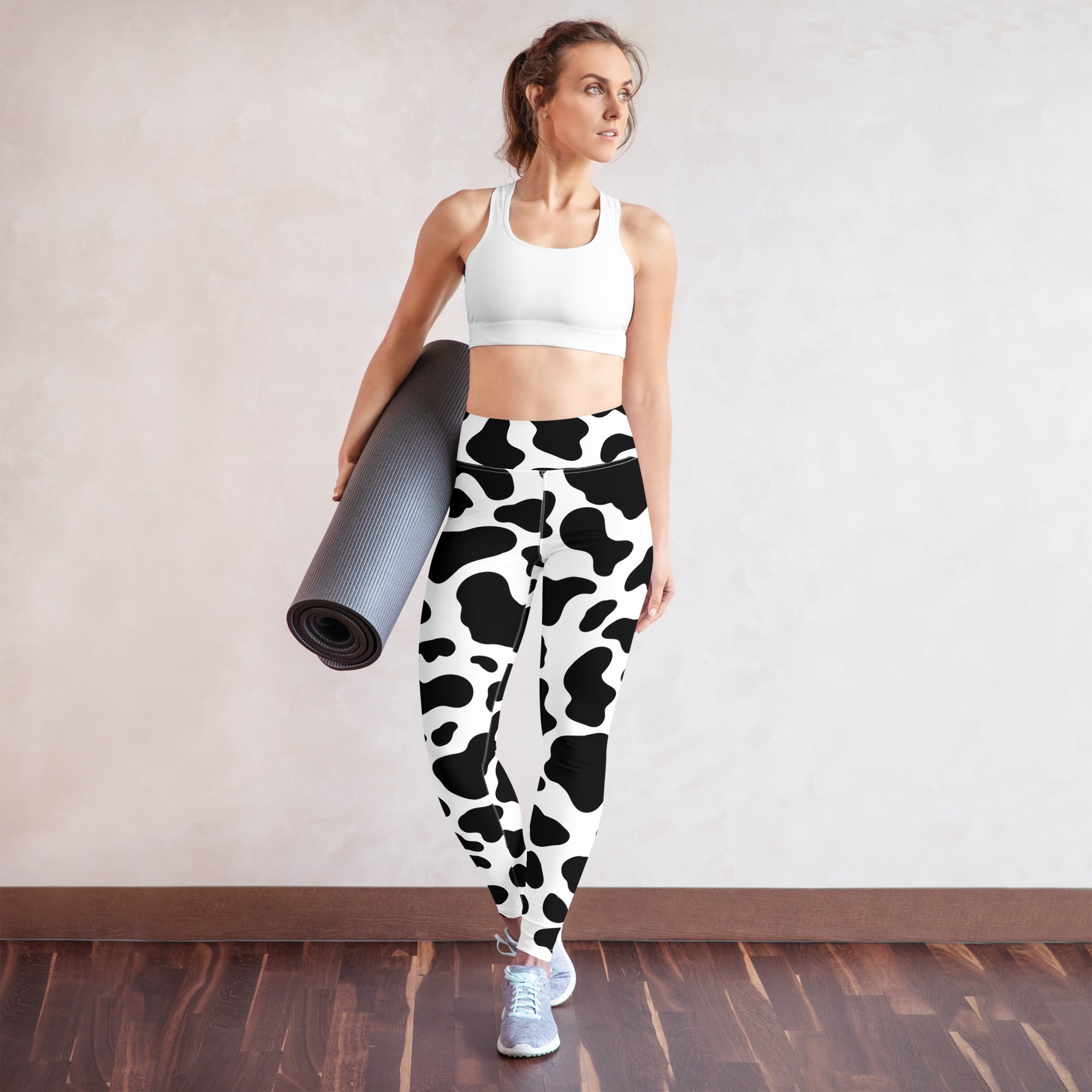 Women’s cow print buttery soft high-waisted yoga leggings in black and white cow pattern shown from the back