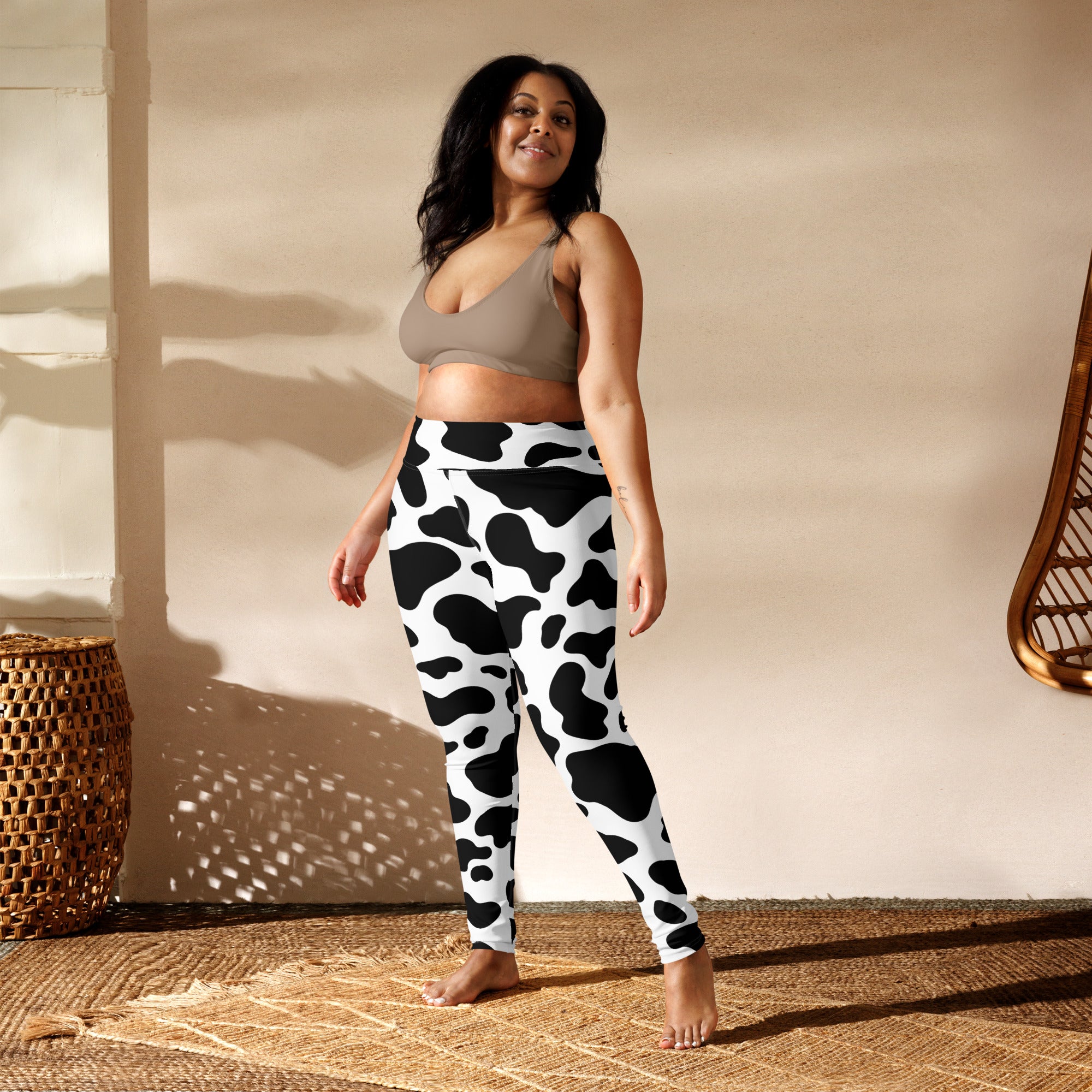 Women’s buttery soft yoga leggings in black and white cow print showing the back side of the design