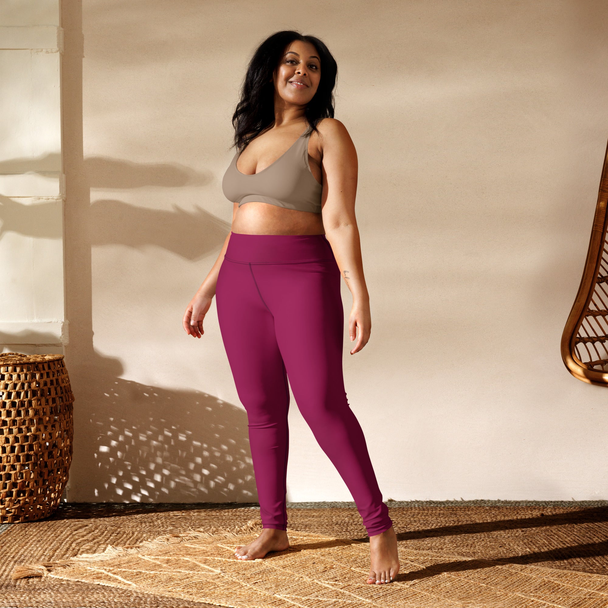 A pair of dark magenta high-waisted buttery soft yoga leggings made from stretchy form-fitting fabric