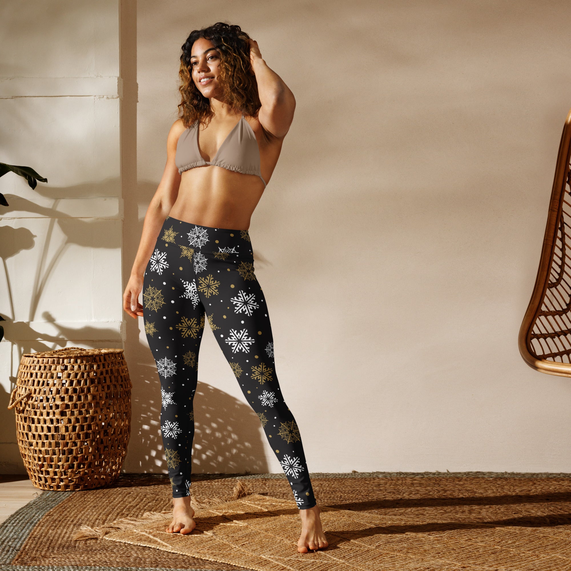 Women’s black buttery soft yoga leggings with white and gold snowflake patterns for winter workouts