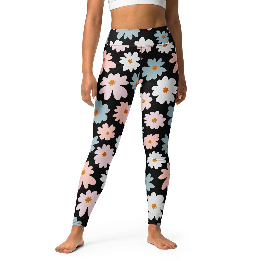 Black high-waisted buttery soft yoga leggings with vibrant pink white and blue daisies and orange centers for women