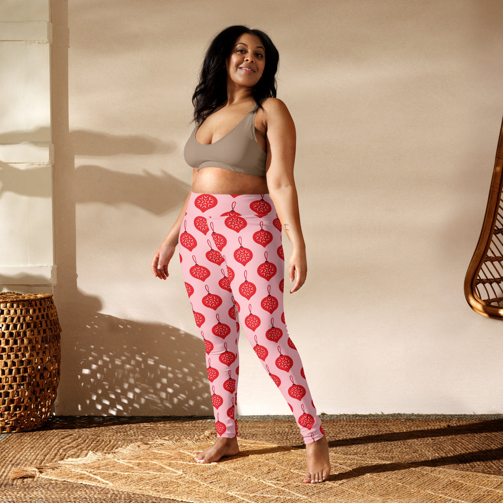 Women’s pink buttery soft yoga leggings with a repeating pattern of red ornamental Christmas baubles