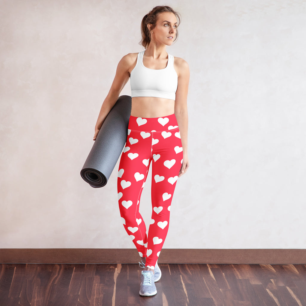 Women’s bright pink high waisted yoga leggings with white heart print made from buttery soft quick drying fabric