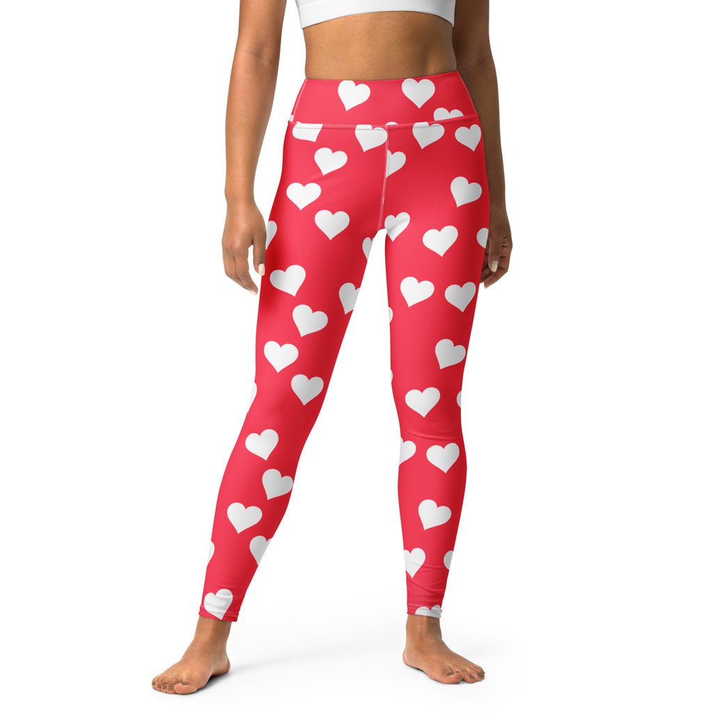 Women’s bright pink high waisted yoga leggings with red heart print made from buttery soft quick drying fabric