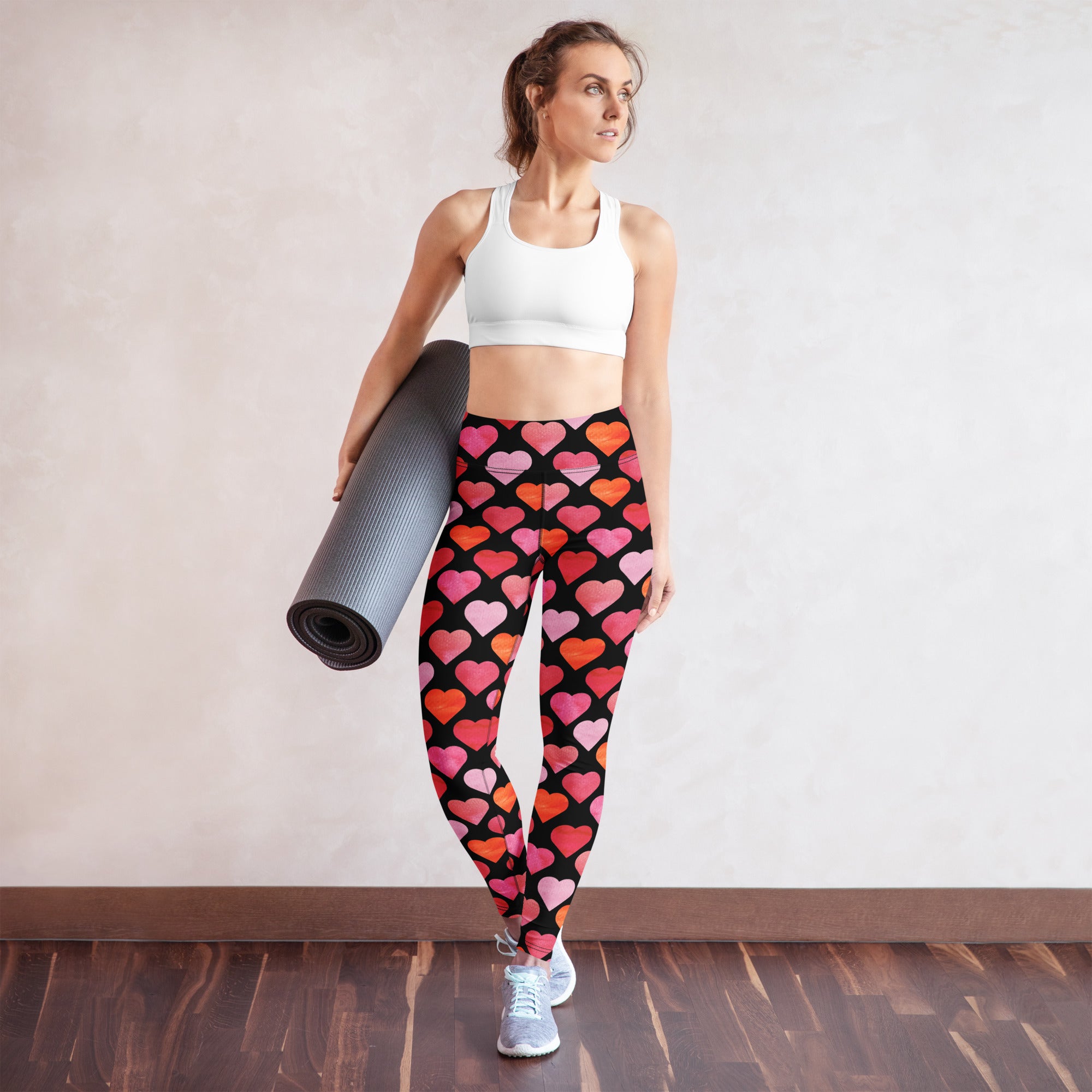 Black women’s high waisted buttery soft yoga leggings with vibrant pink and orange watercolor heart pattern
