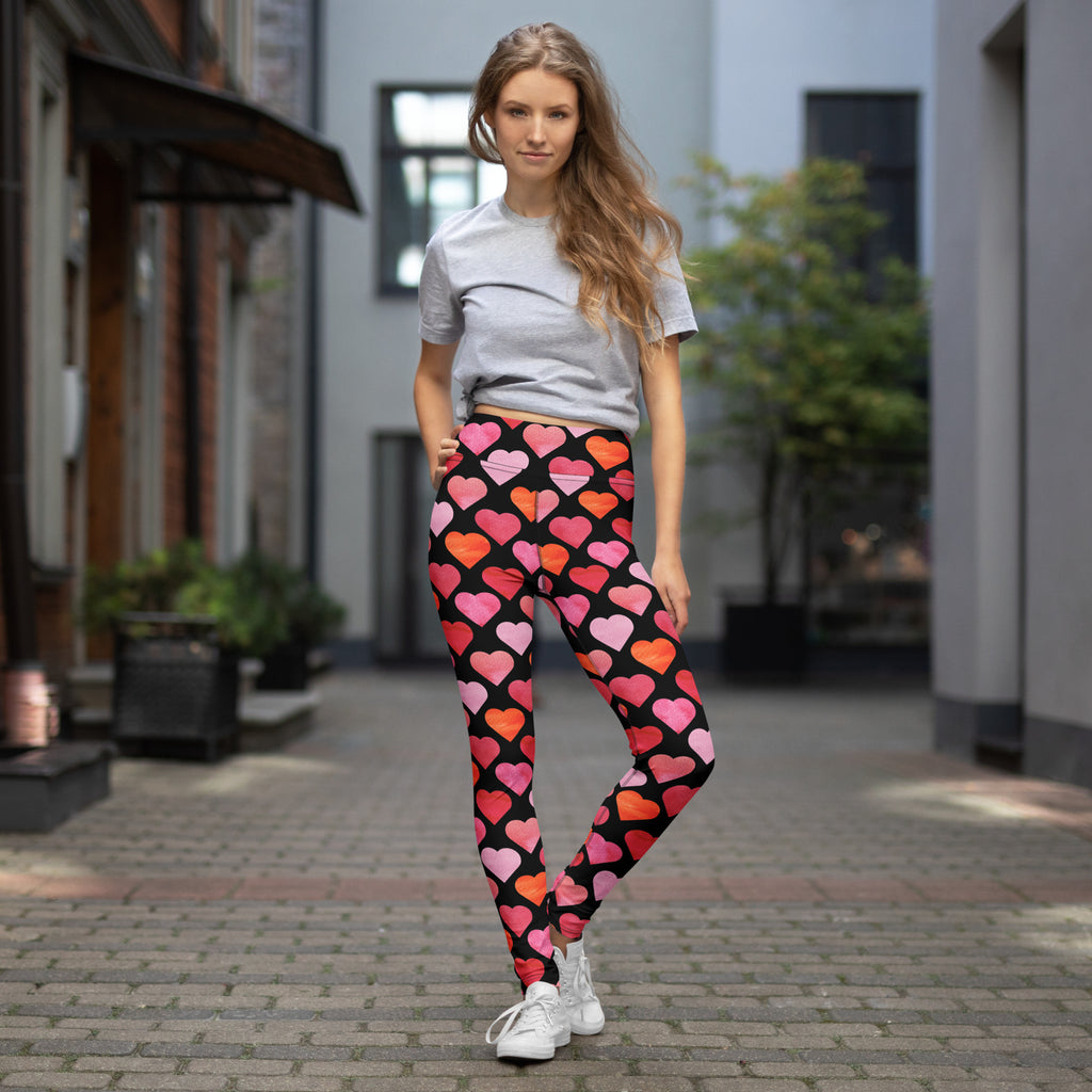 Black women’s high waisted buttery soft yoga leggings with vibrant pink and orange watercolor heart pattern