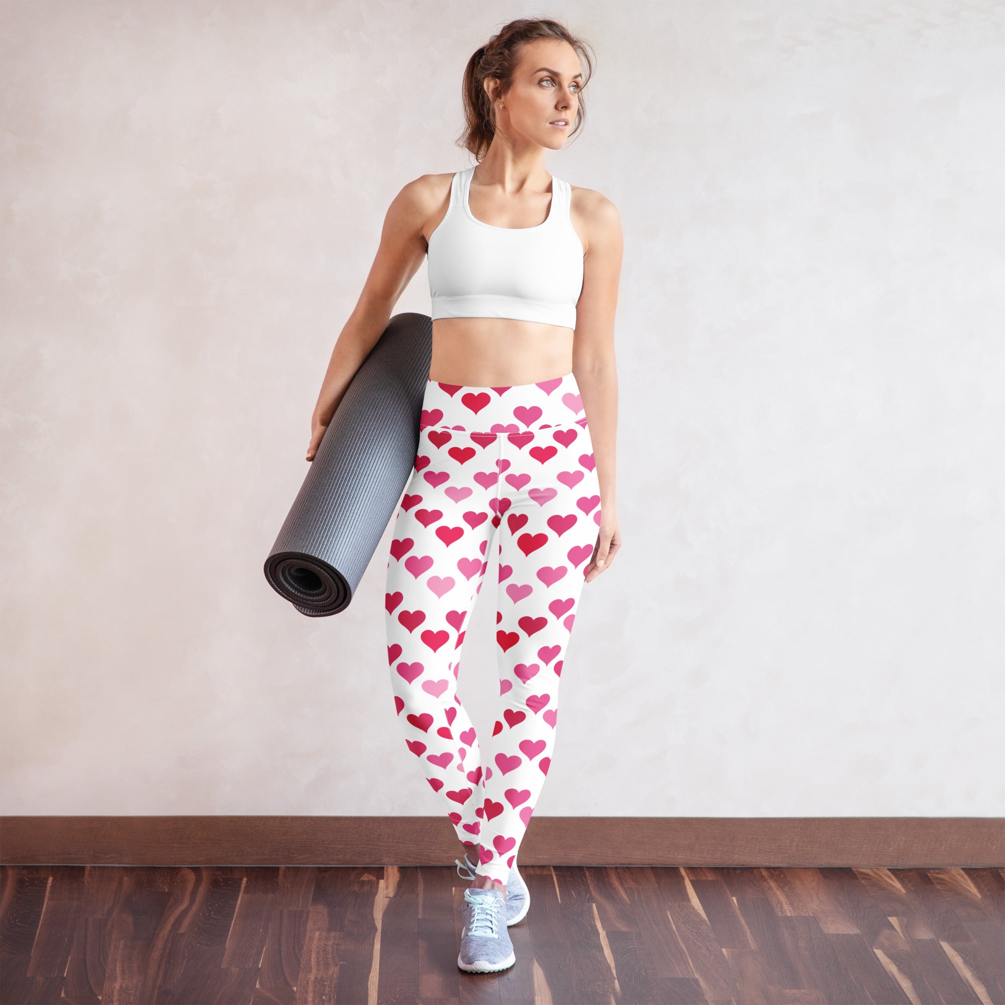 White women’s high waisted yoga leggings with pink heart pattern made of buttery soft quick drying fabric