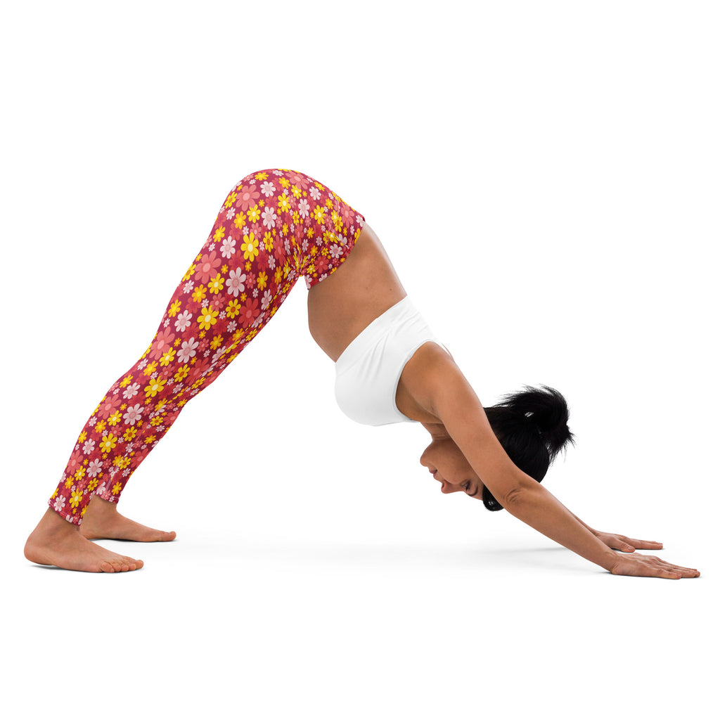 A woman wearing vibrant pink and yellow red floral buttery soft yoga leggings with a white sports bra
