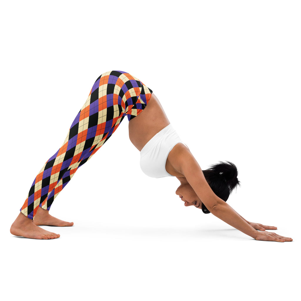 A woman wearing women’s halloween argyle buttery soft yoga leggings with vibrant orange purple black and cream diamonds