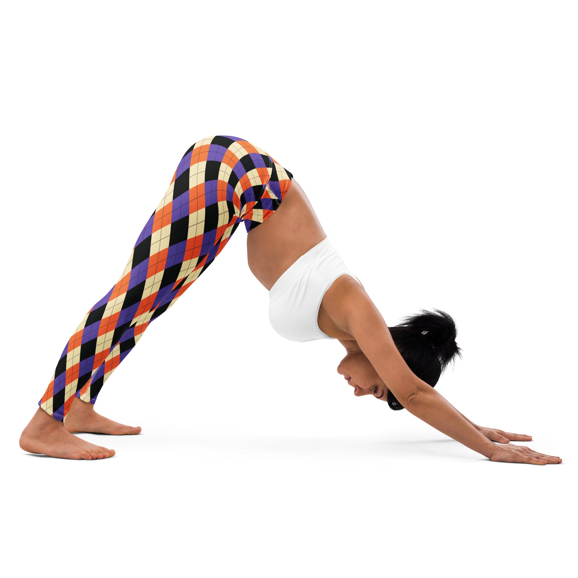 A woman wearing women’s halloween argyle buttery soft yoga leggings with vibrant orange purple black and cream diamonds