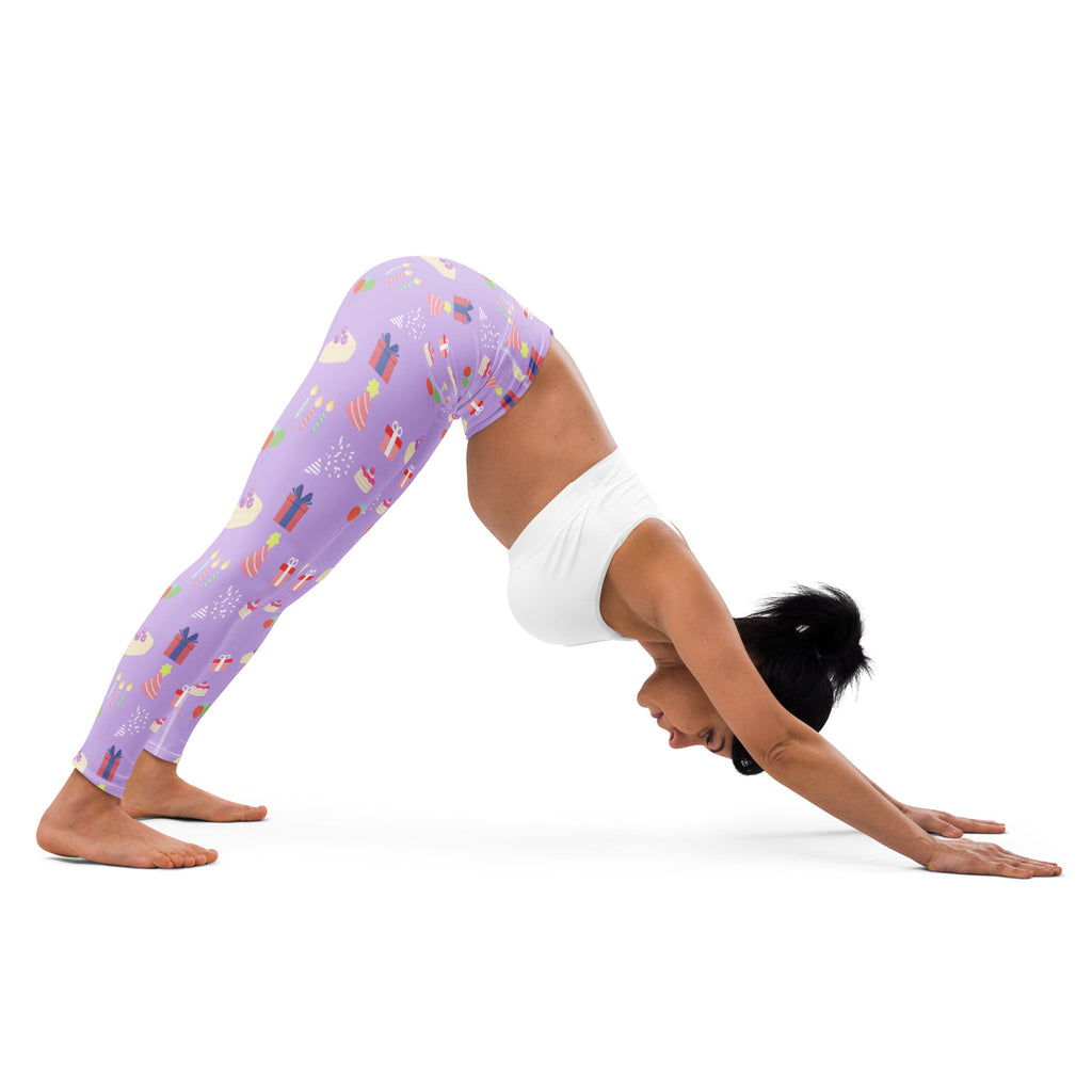 Women’s purple buttery soft yoga leggings with a festive birthday pattern of wrapped gifts and holiday motifs