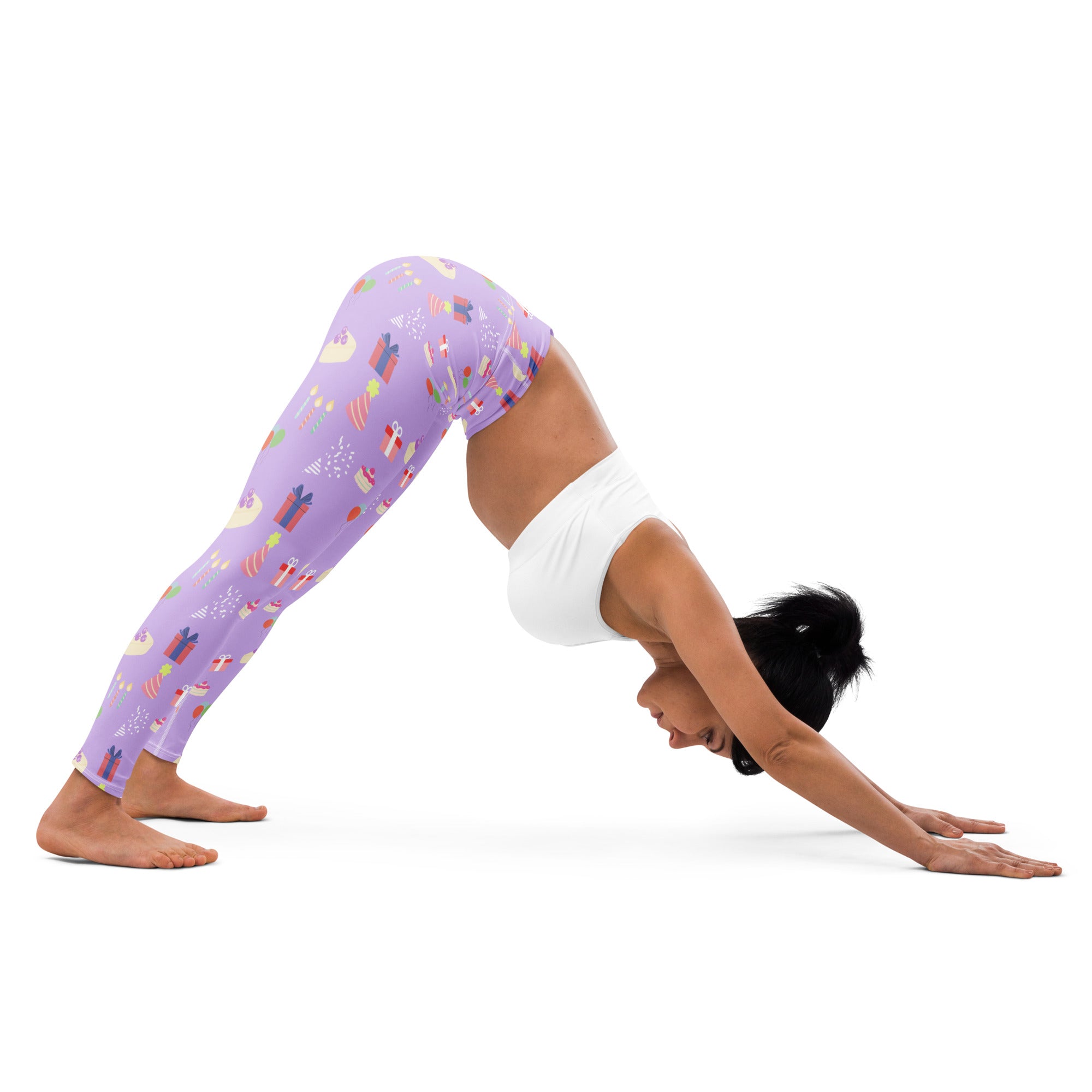 Women’s purple buttery soft yoga leggings with a festive birthday pattern of wrapped gifts and holiday motifs