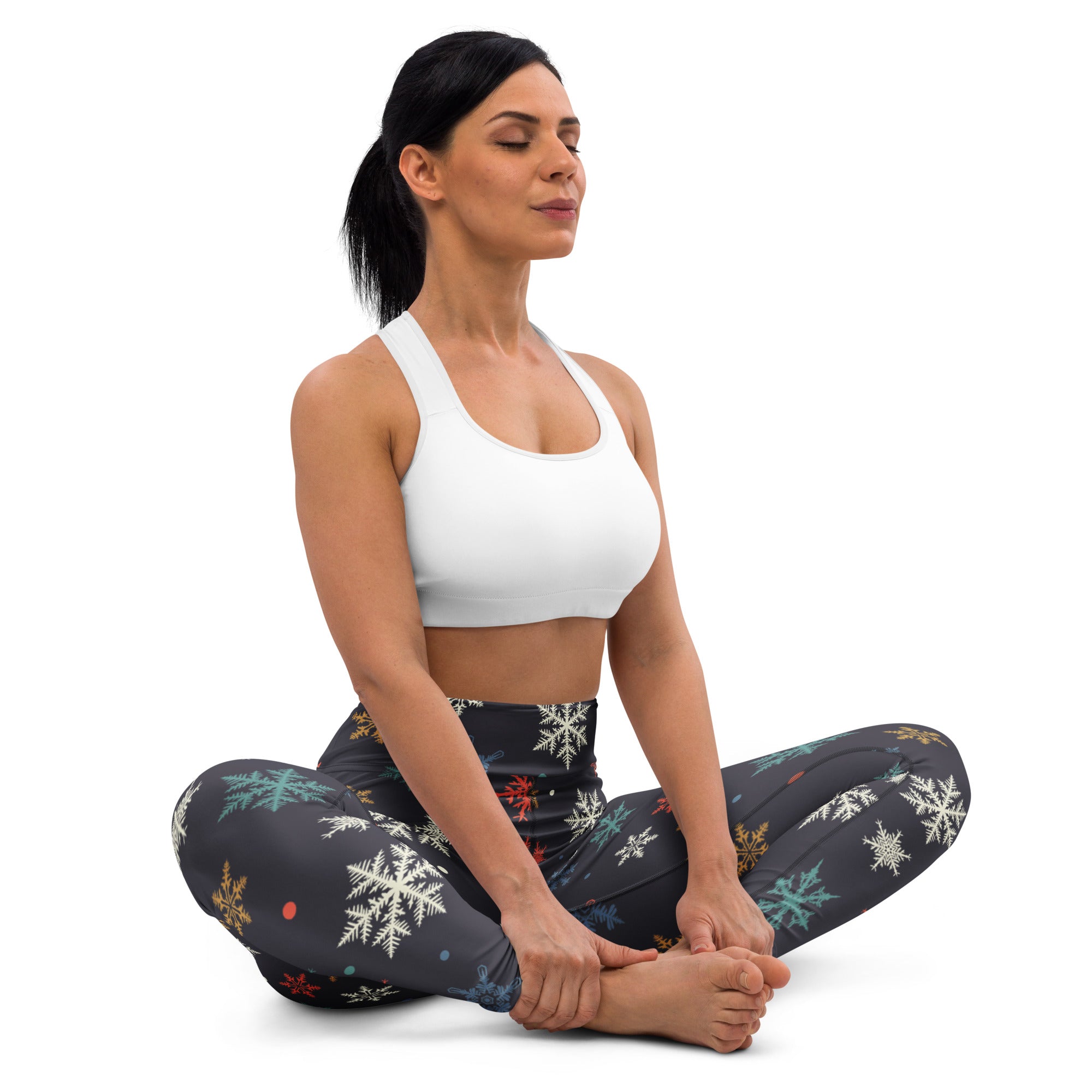 Black leggings with white teal red and gold snowflake pattern in buttery soft fabric for women’s winter yoga