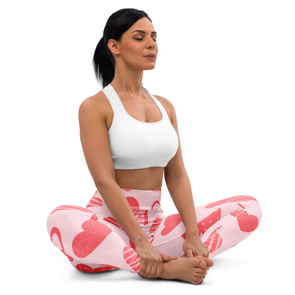 Women’s pink heart pattern buttery soft yoga leggings with quick drying high waisted comfort shown with white sports bra
