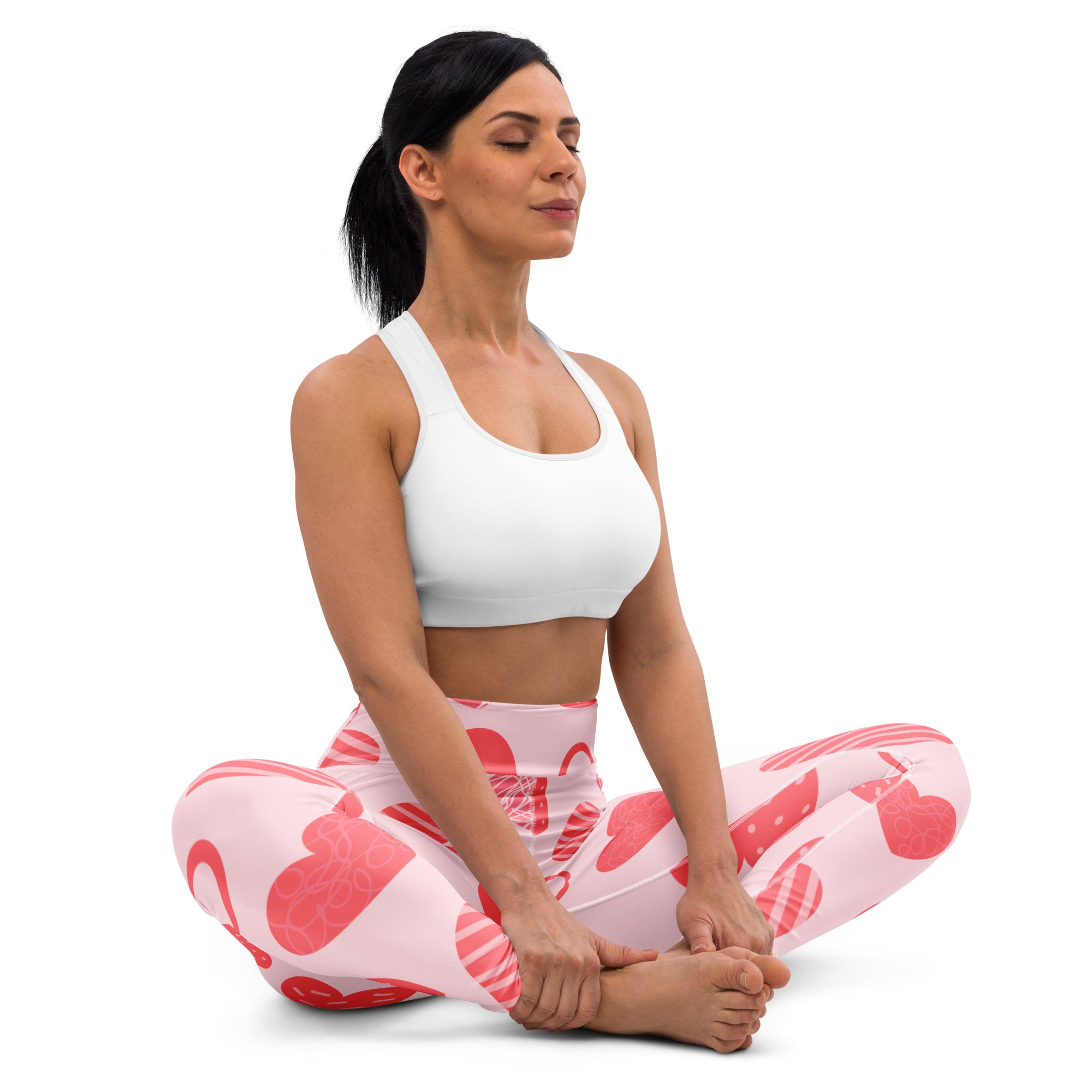 Women’s pink heart pattern buttery soft yoga leggings with quick drying high waisted comfort shown with white sports bra
