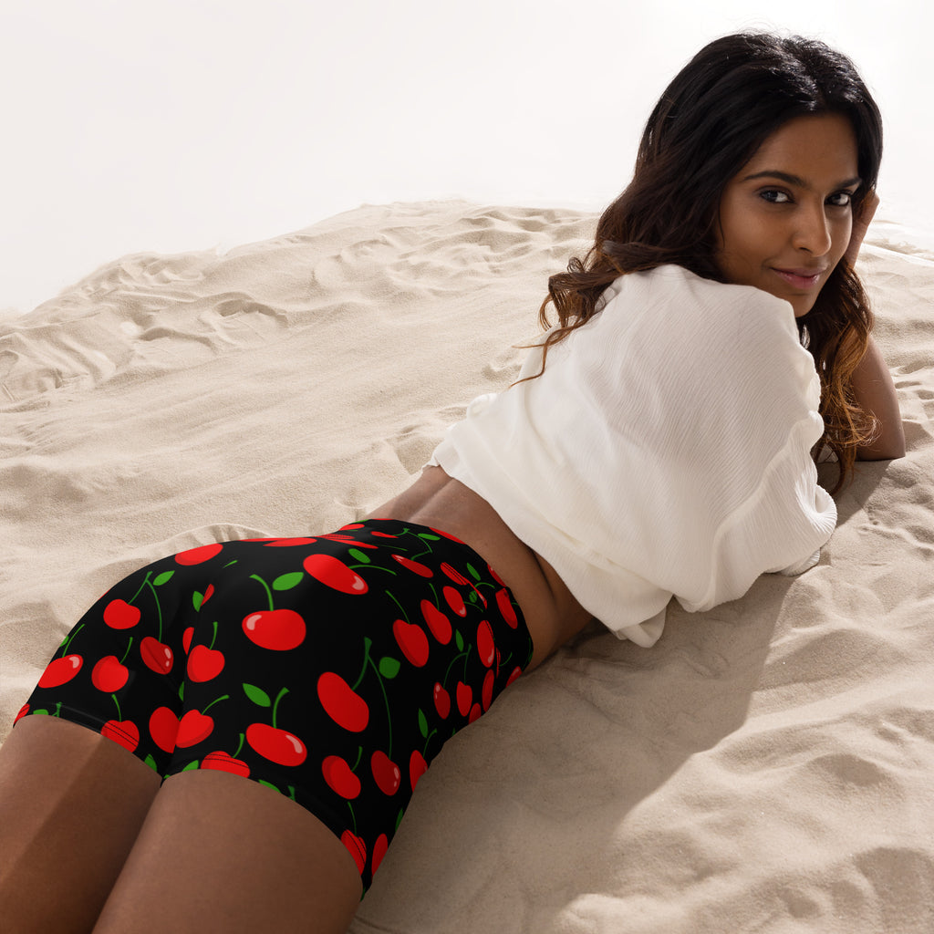 Women’s high waisted buttery soft black yoga shorts with vibrant red cherry print and green stems and leaves