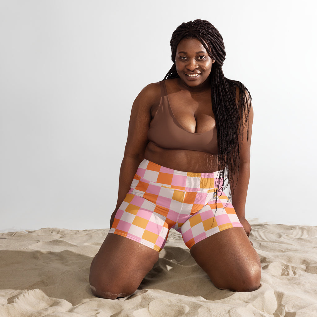A pair of women’s high waisted pink and orange checkered yoga shorts made from stretchy buttery soft fabric