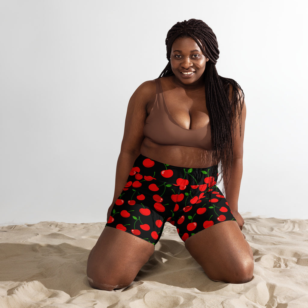 Women’s high waisted buttery soft black yoga shorts with vibrant red cherry pattern and green stems and leaves