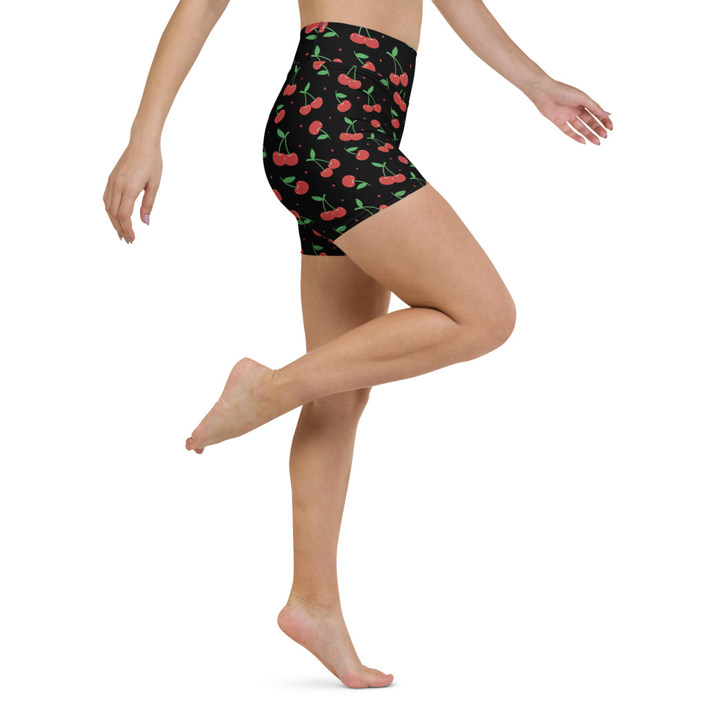 Women’s black high waisted buttery soft yoga shorts with vibrant red cherry pattern and green stems and leaves