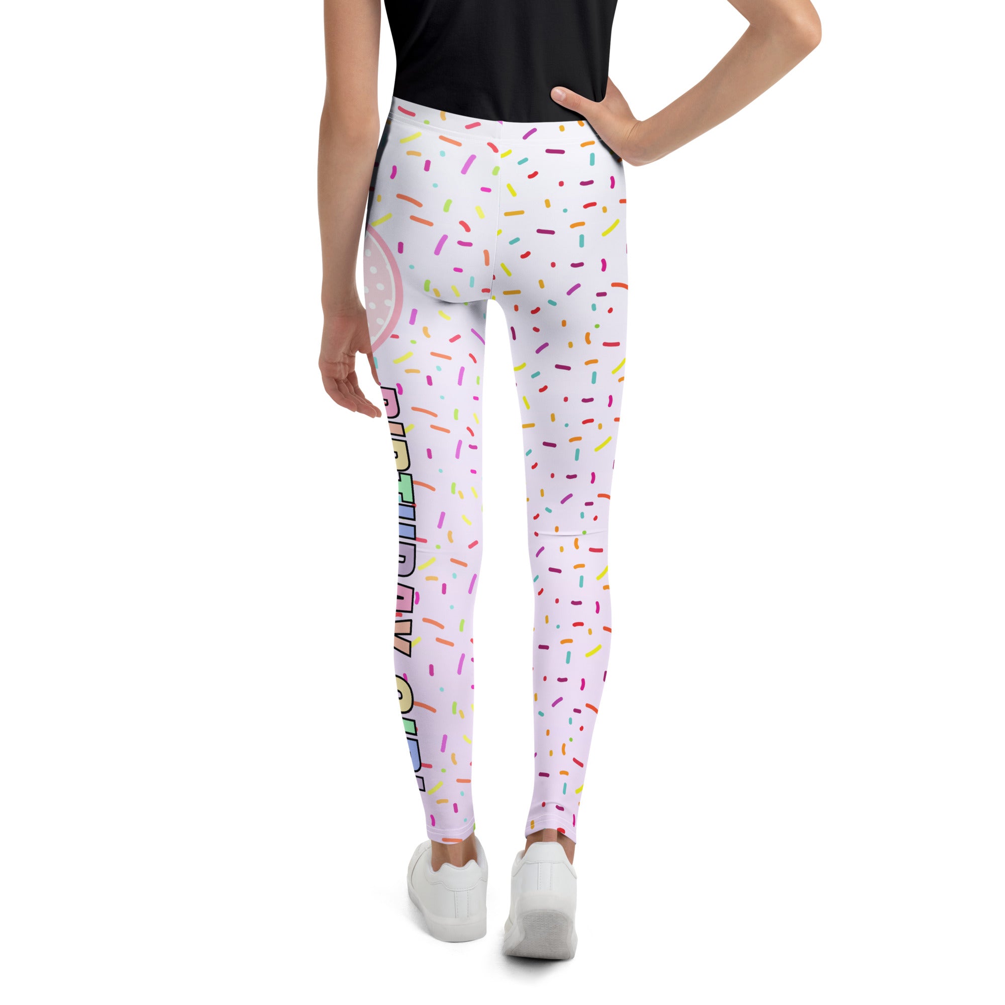 White buttery soft leggings with colorful sprinkle pattern and vertical rainbow birthday text for birthday girl use