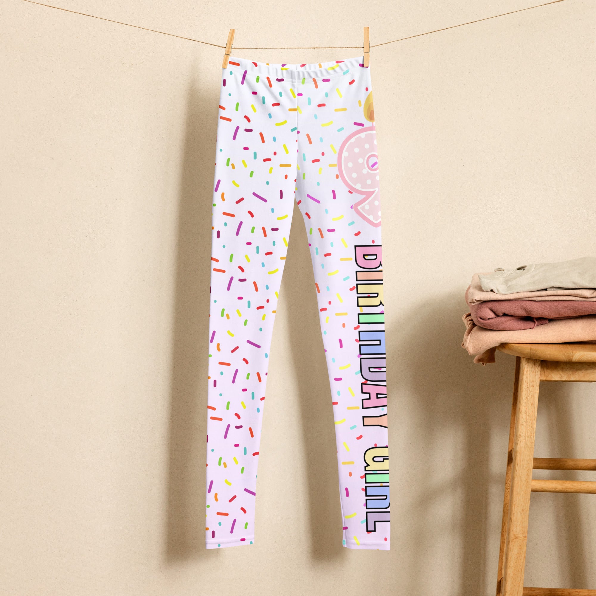 White buttery soft leggings with colorful sprinkle patterns pink donut graphic and rainbow birthday girl text on one leg
