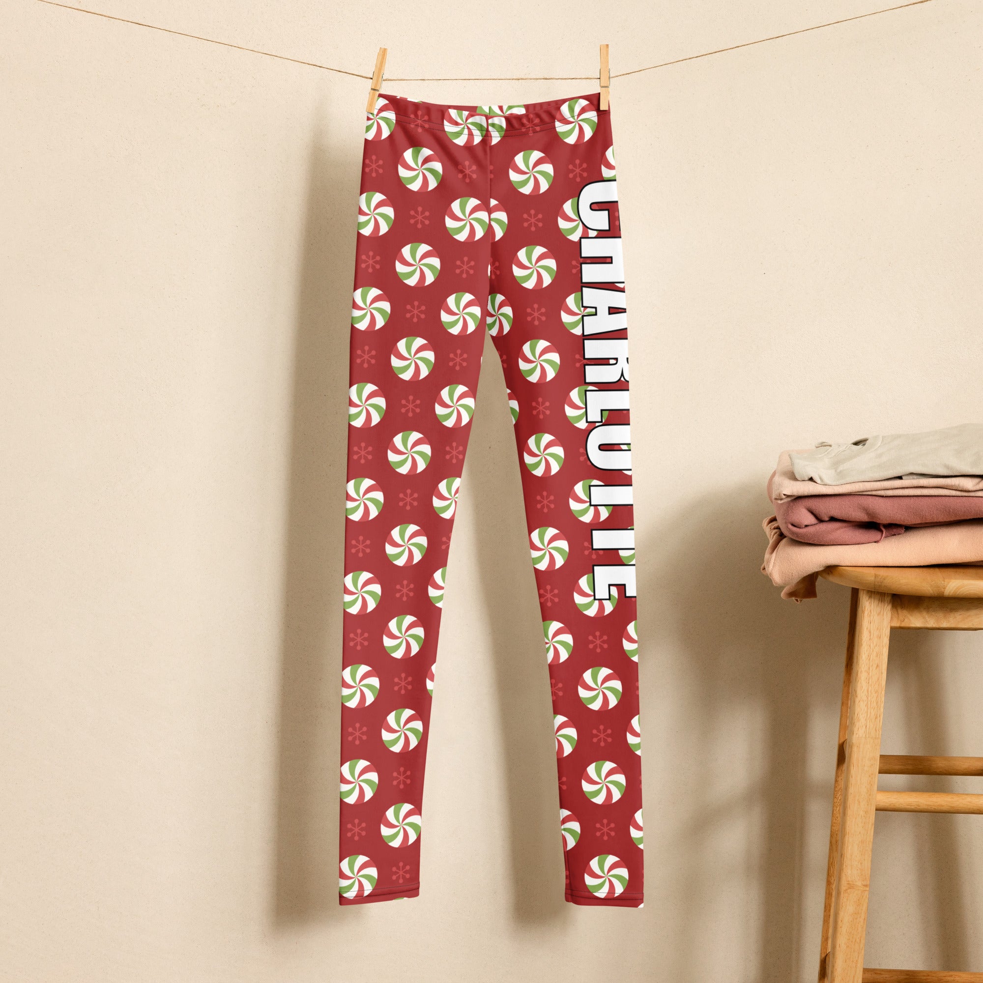 Girls custom name red buttery soft leggings with festive peppermint candy snowflake pattern and charlotte lettering