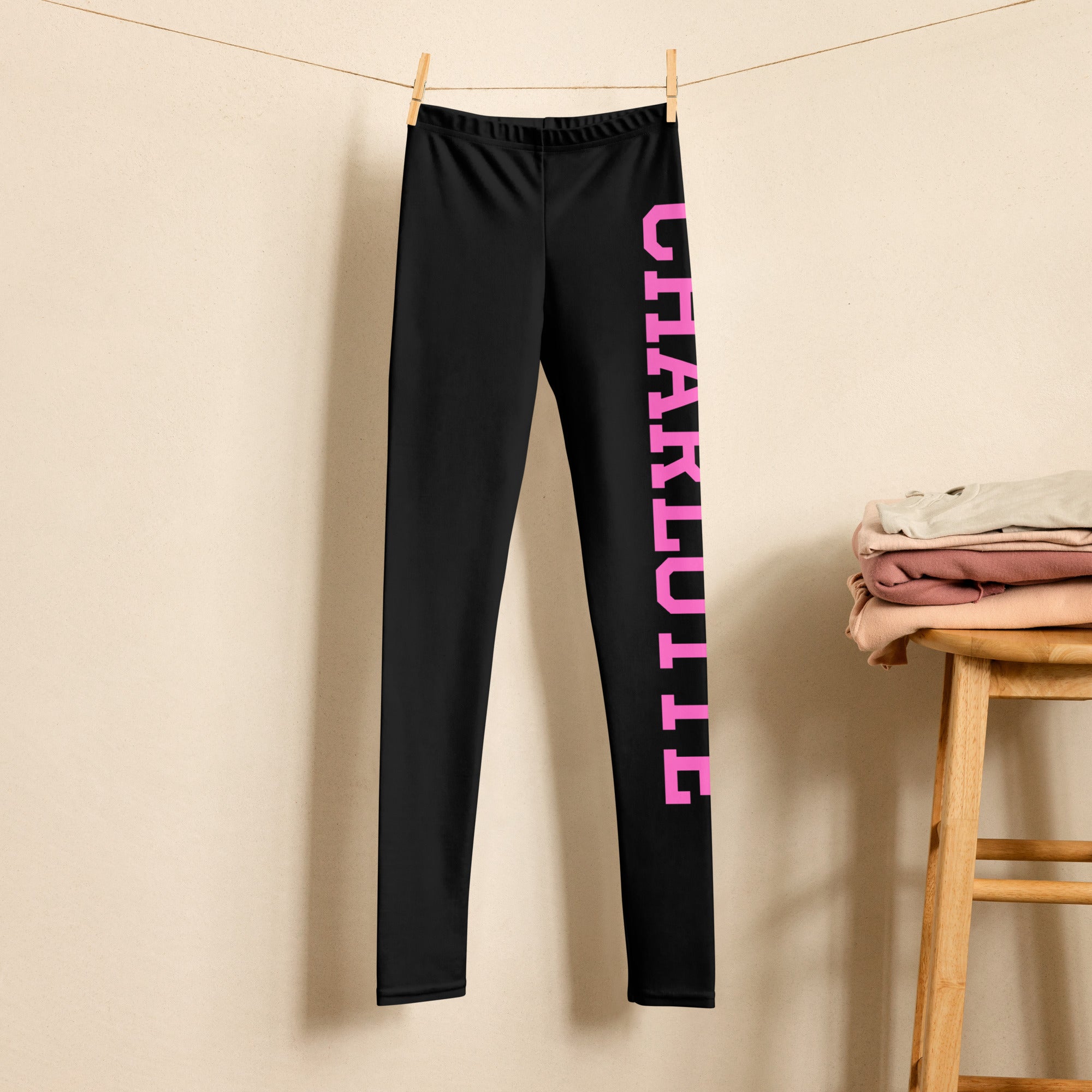 Black girls sports leggings with bold pink charlotte varsity font lettering down the outer leg buttery soft material