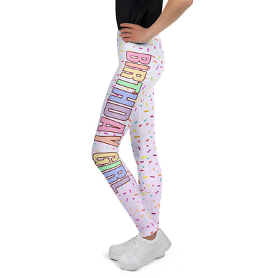 Pastel pink buttery soft leggings with colorful birthday girl rainbow lettering and multicolored sprinkle patterns