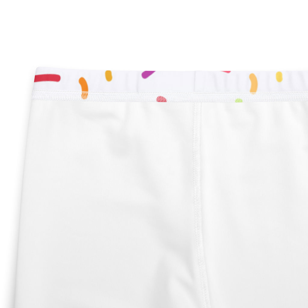 White buttery soft leggings with colorful orange red purple and yellow abstract shapes along the waistband